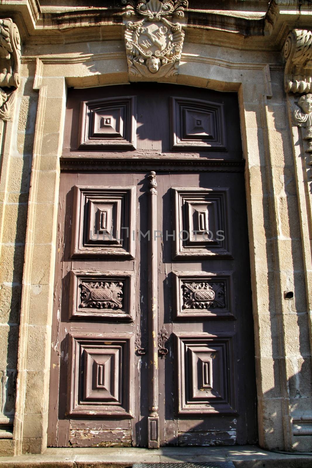 Old wooden carved brown door in Porto, Portugal