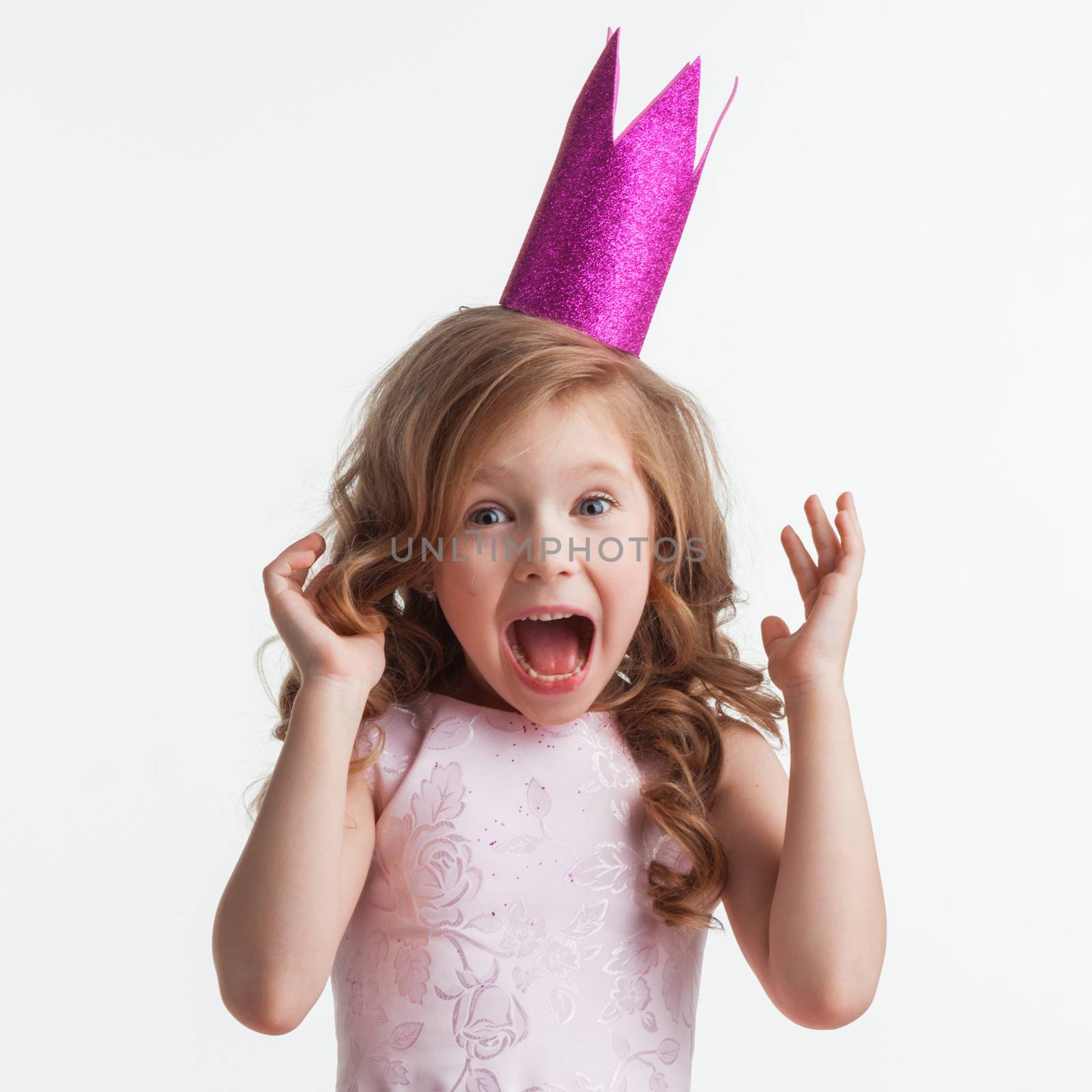 Little cute surprised girl in pink halloween princess costume and crown isolated on white background