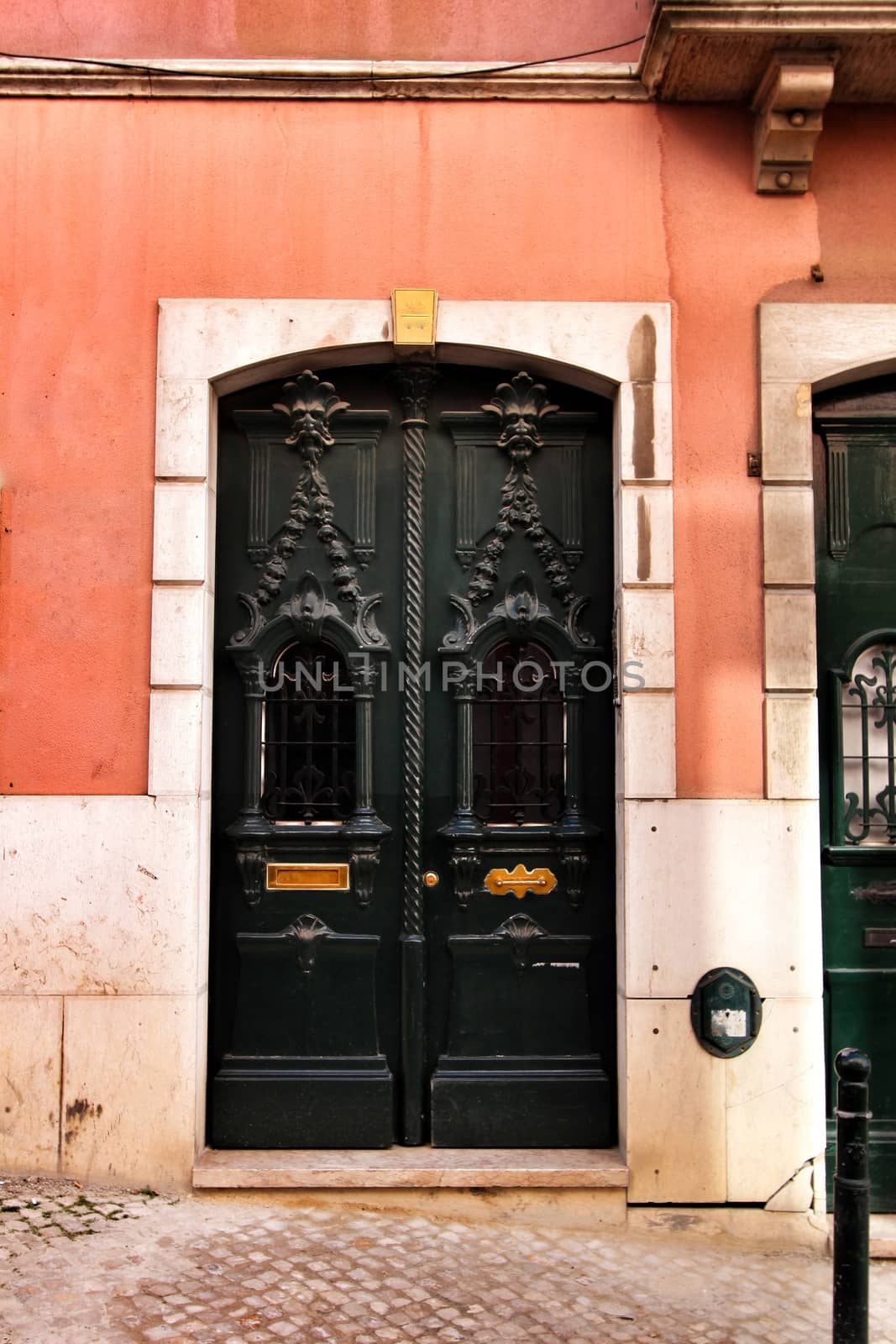 Old and colorful carved wood door with iron details in Lisbon, Portugal