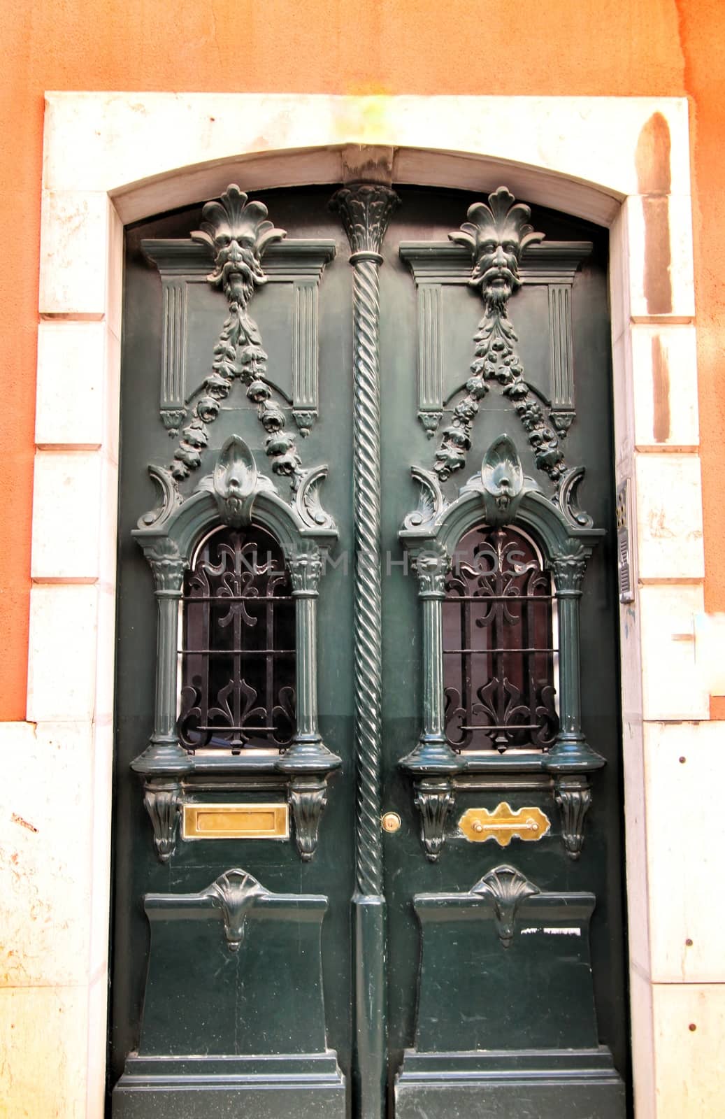 Old and colorful carved wood door with iron details in Lisbon, Portugal