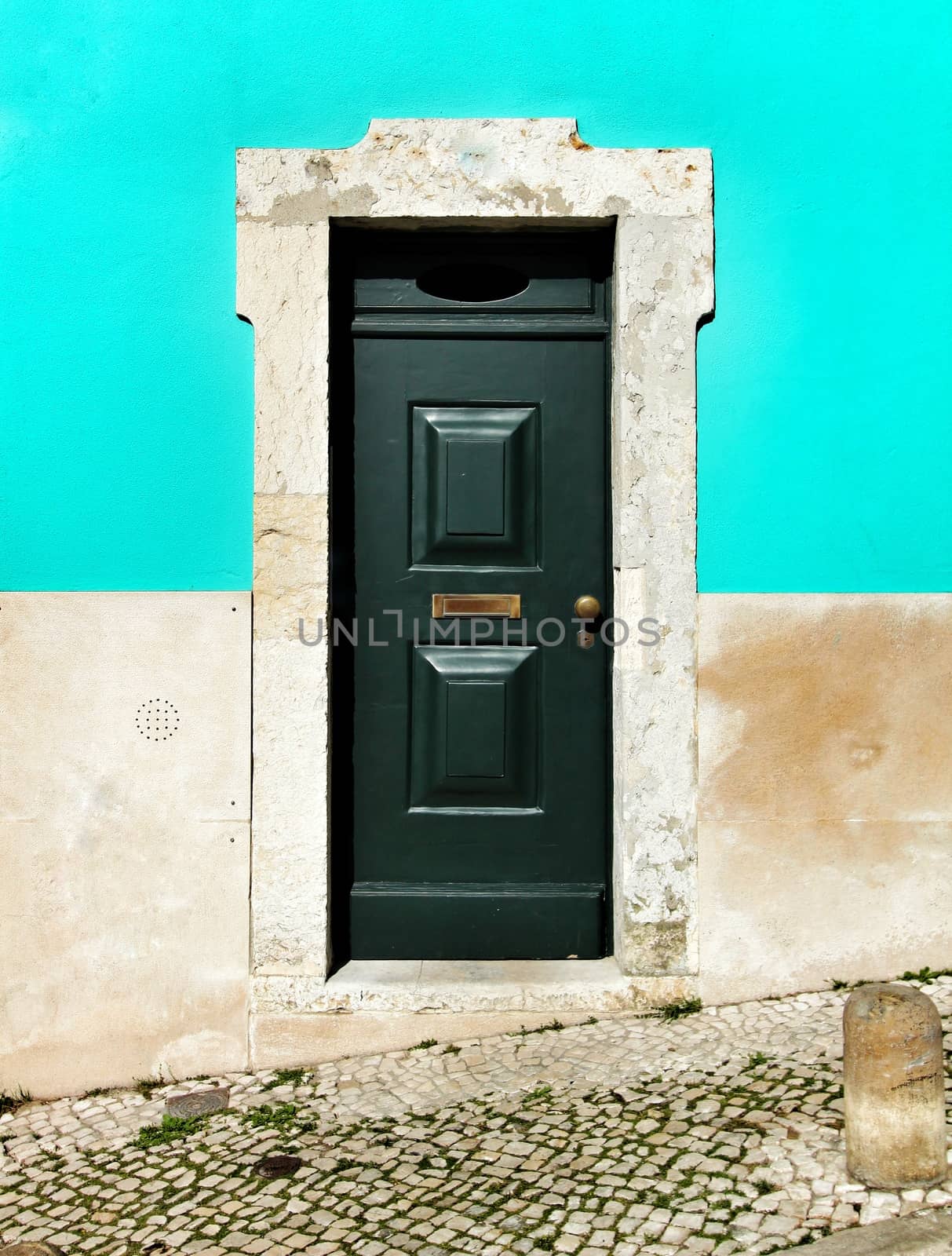Old and colorful facade and wooden door with iron details in Lisbon, Portugal