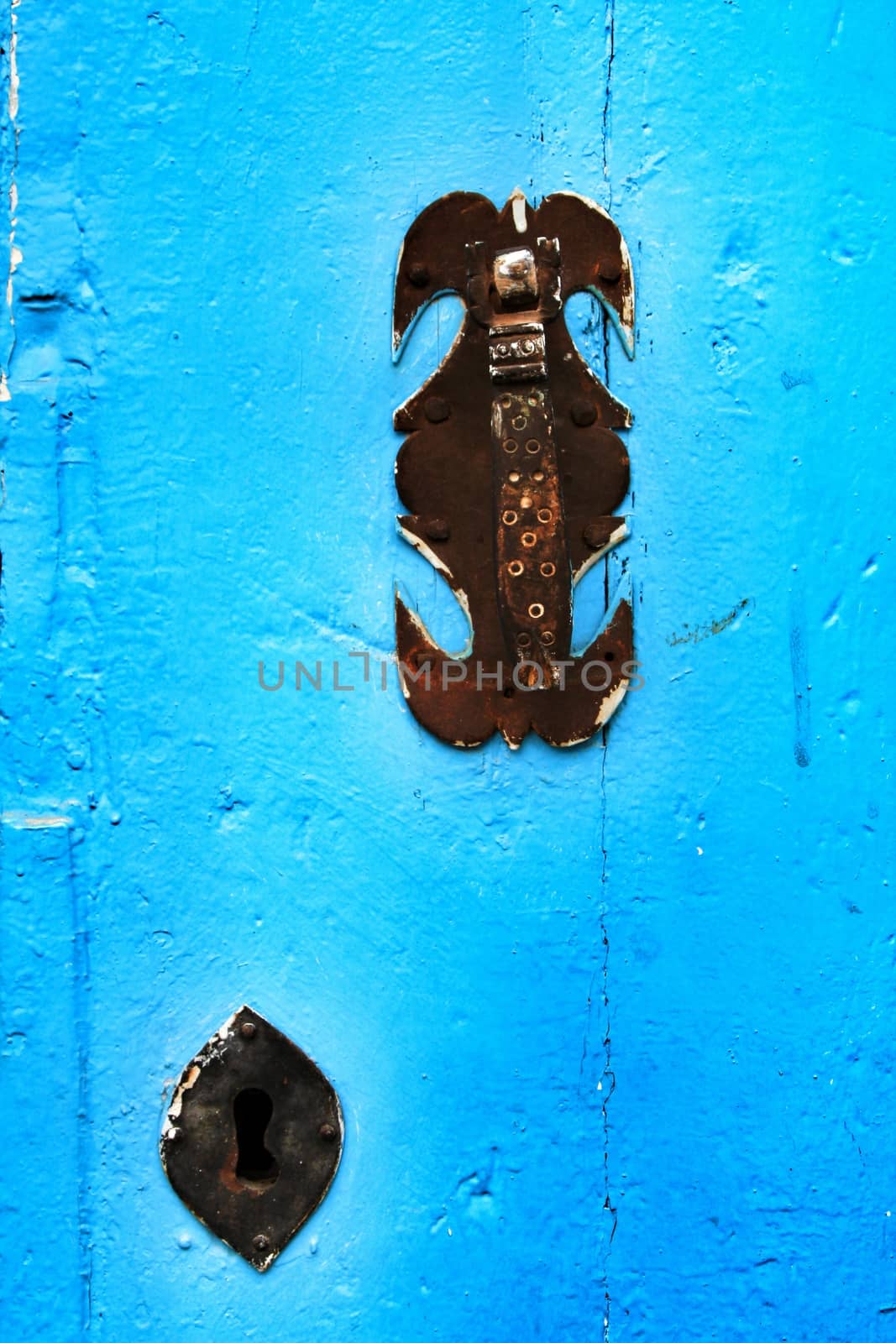 Old and colorful blue wooden door with iron details by soniabonet