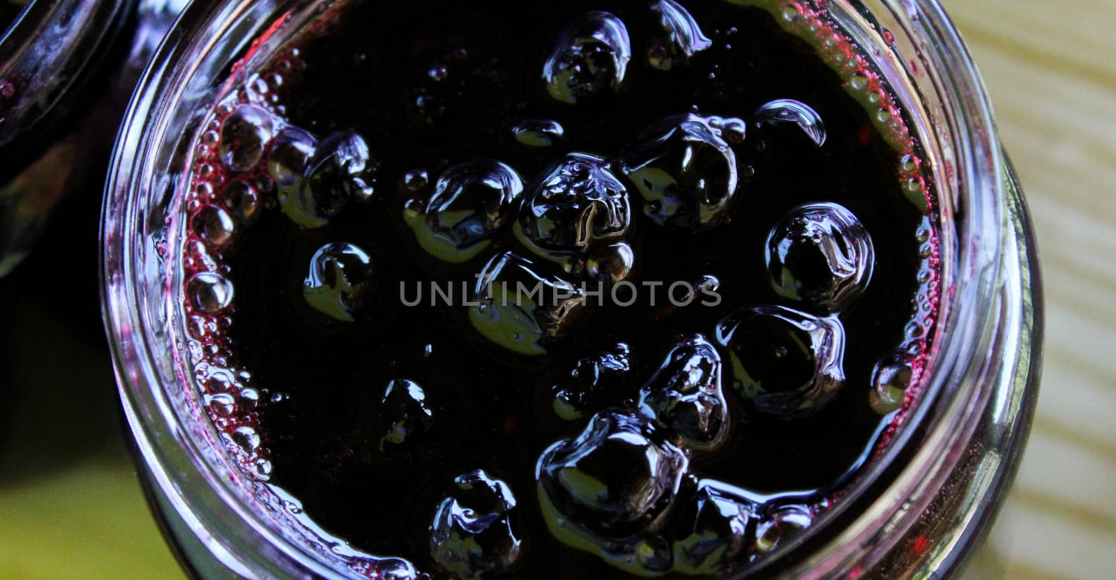 Banner of chokeberry jam in a glass jar. Sweet from aronia. Zavidovici, Bosnia and Herzegovina.