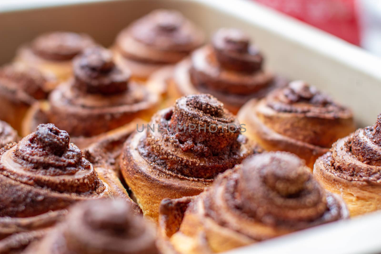 Delicious round cinnamon rolls on a baking sheet after the oven. I cook buns at home in the oven.