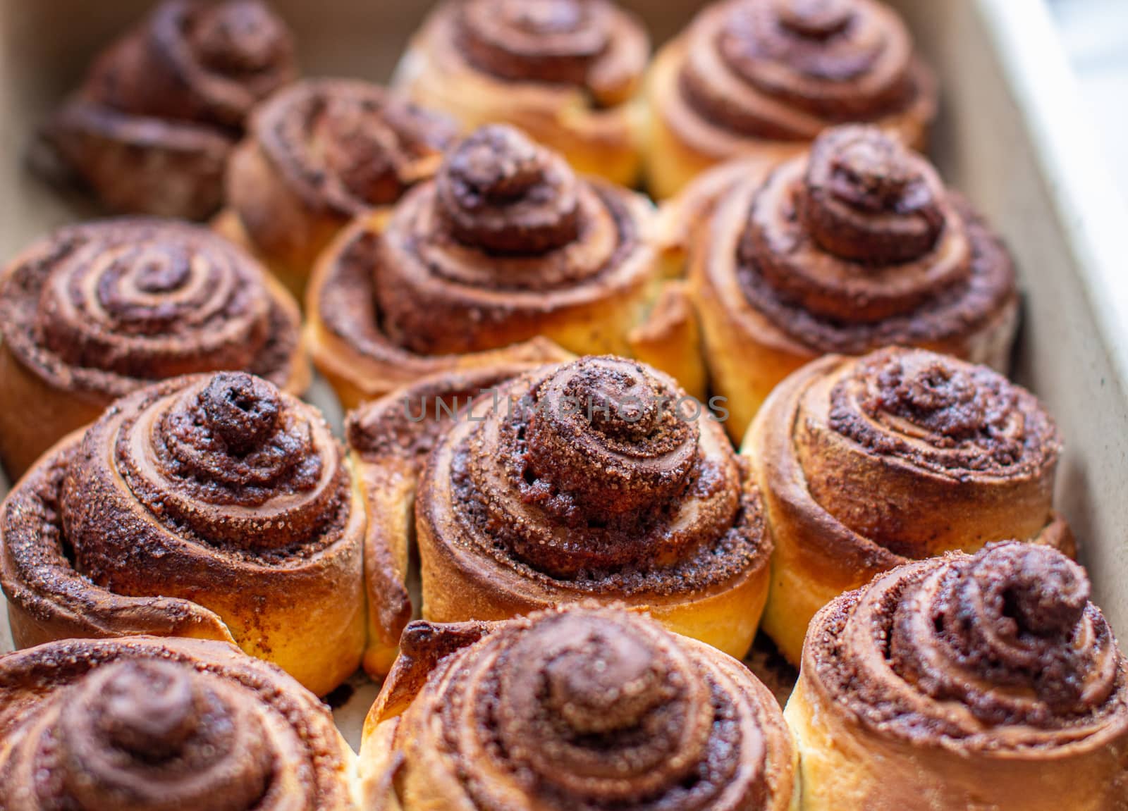 Delicious round cinnamon rolls on a baking sheet after the oven. I cook buns at home in the oven.