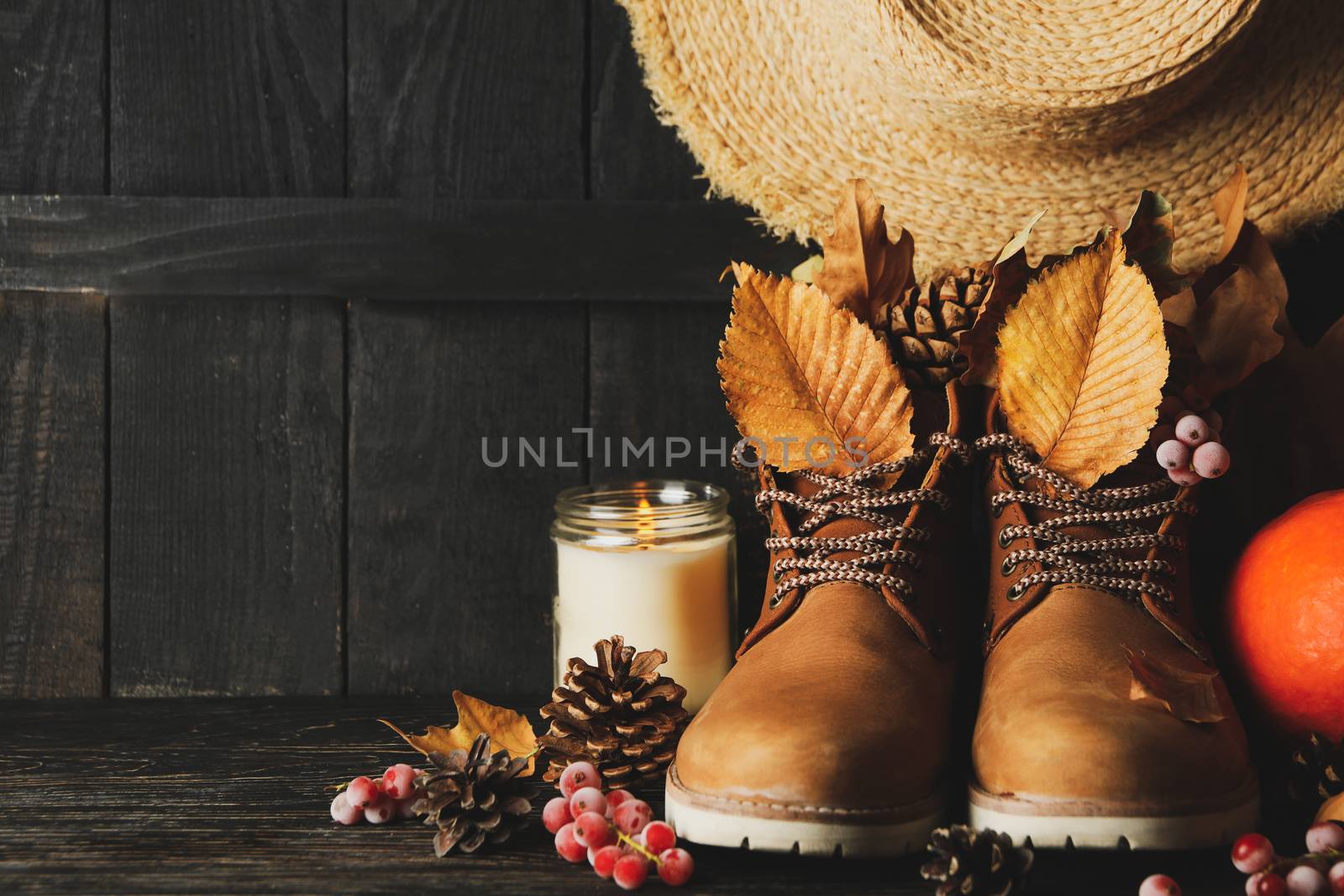 Concept of autumn wear with boots and leaves on wooden background