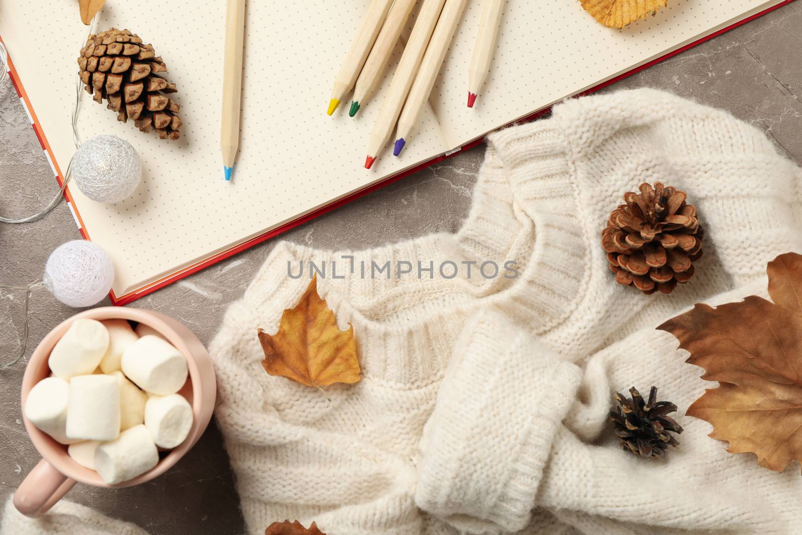 Autumn concept with sweater and coffee on gray background