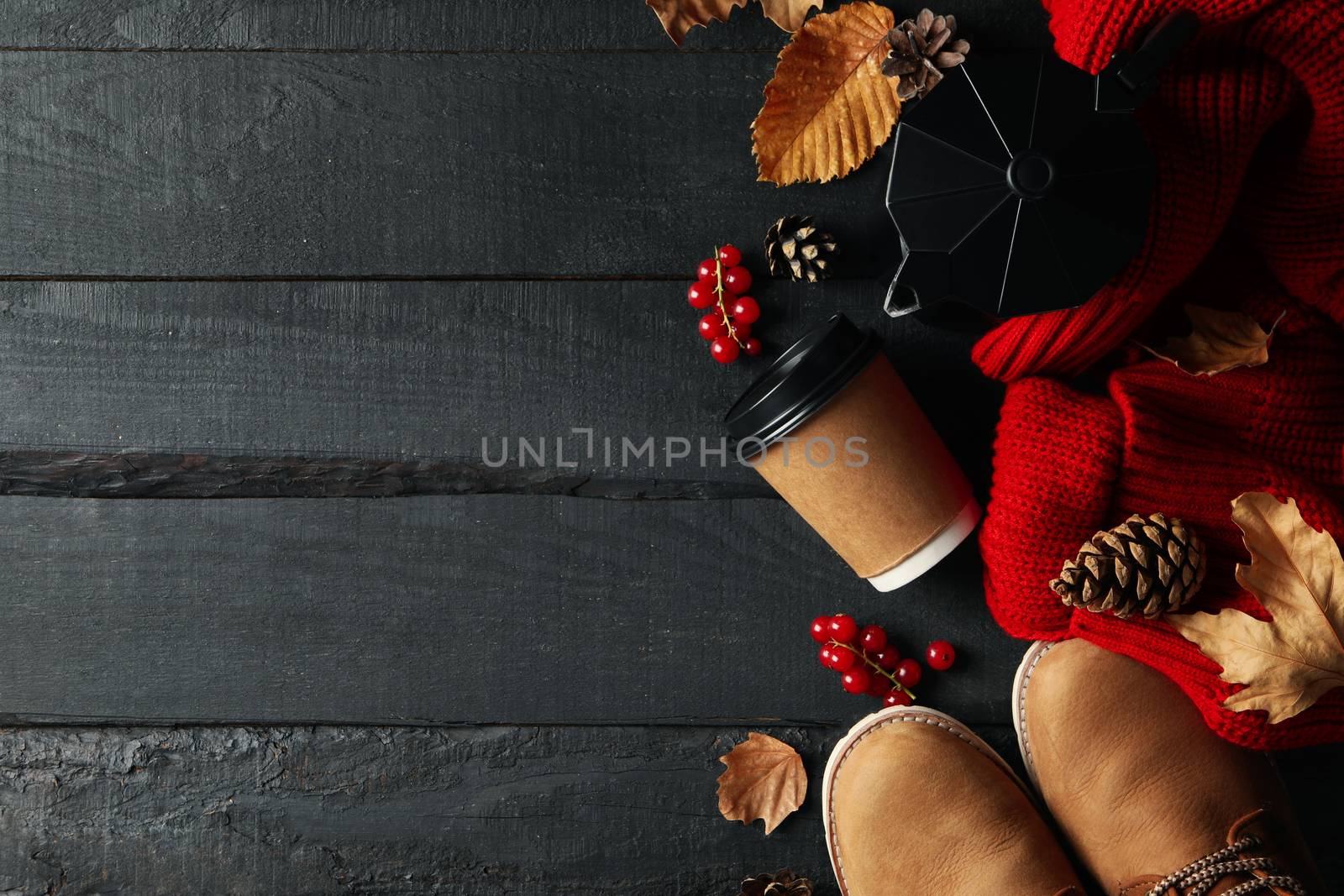 Autumn concept with sweater, coffee and boots on wooden table by AtlasCompany