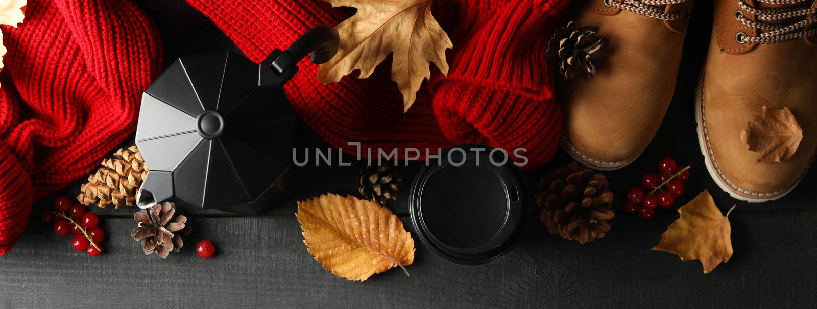 Autumn concept with sweater, coffee and boots on wooden table by AtlasCompany