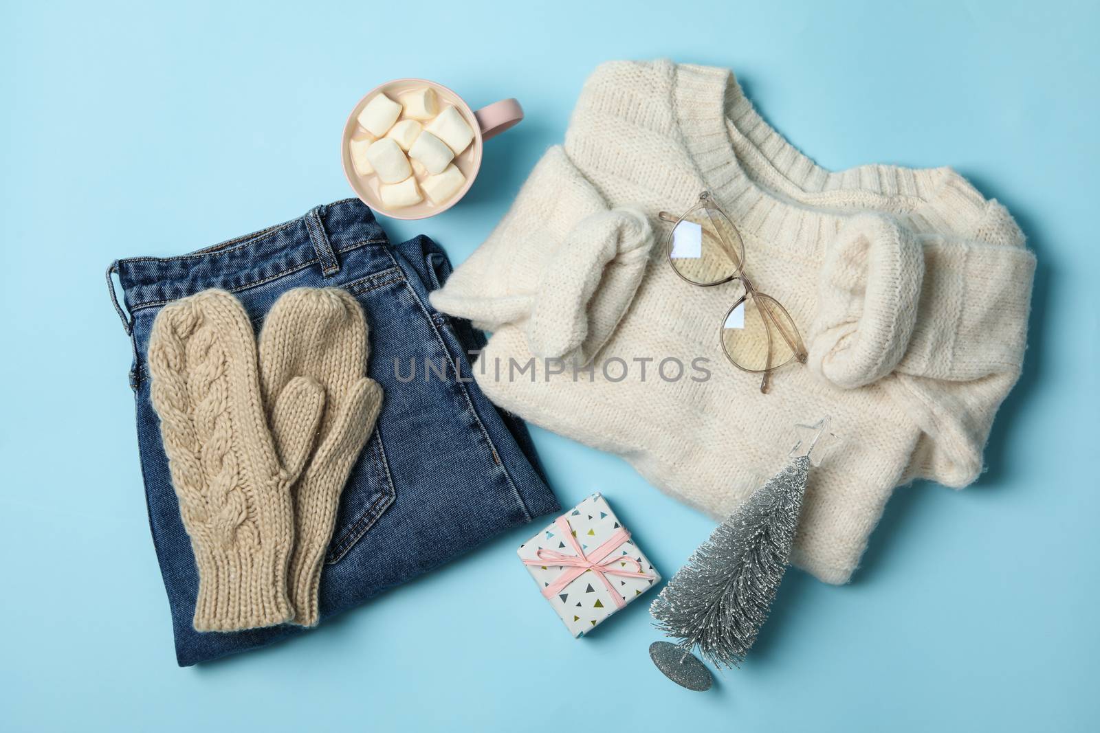 Winter concept with sweater and gift box on blue background