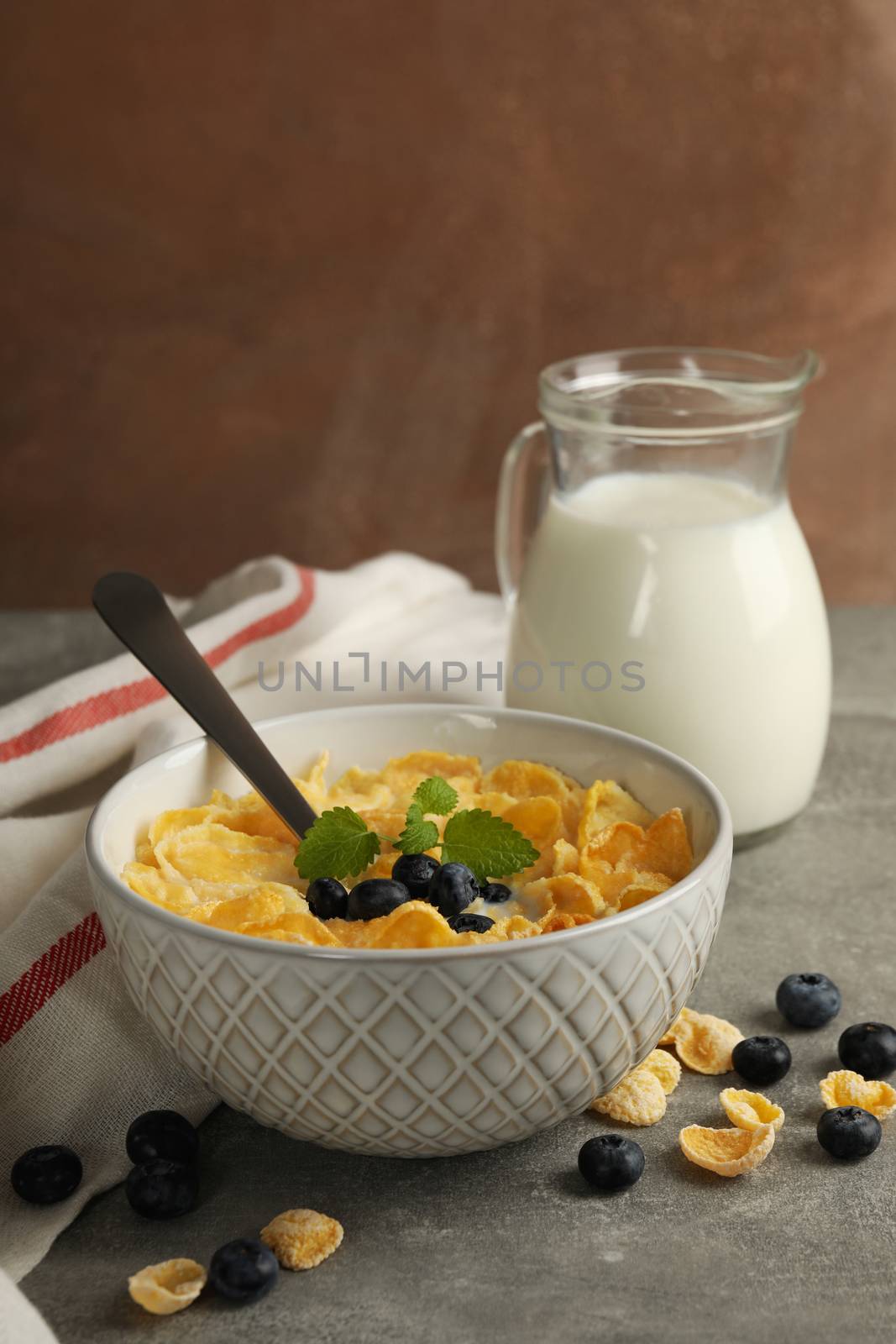 Concept of breakfast with muesli, milk and blueberry on gray table