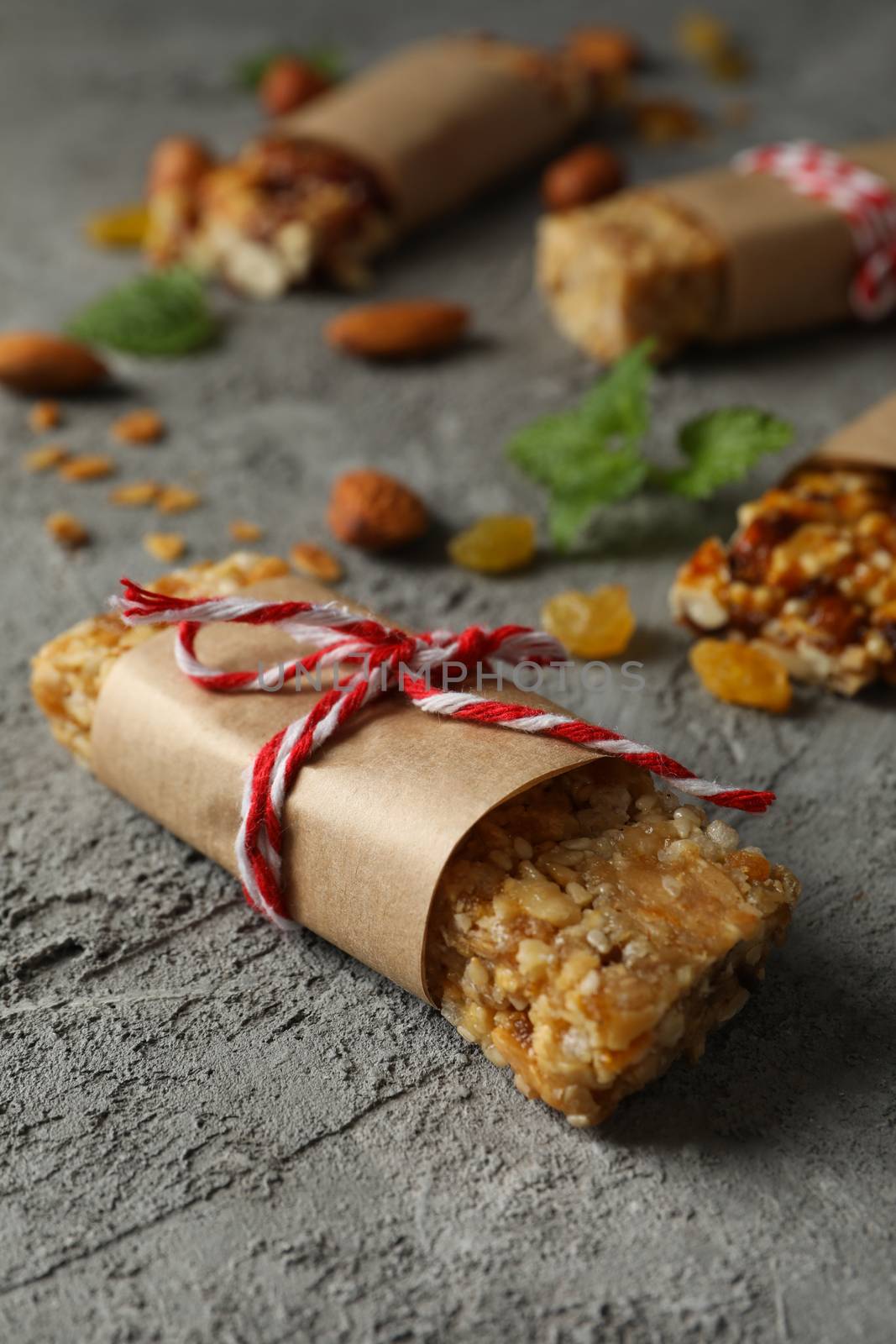 Tasty granola bars on gray background, close up