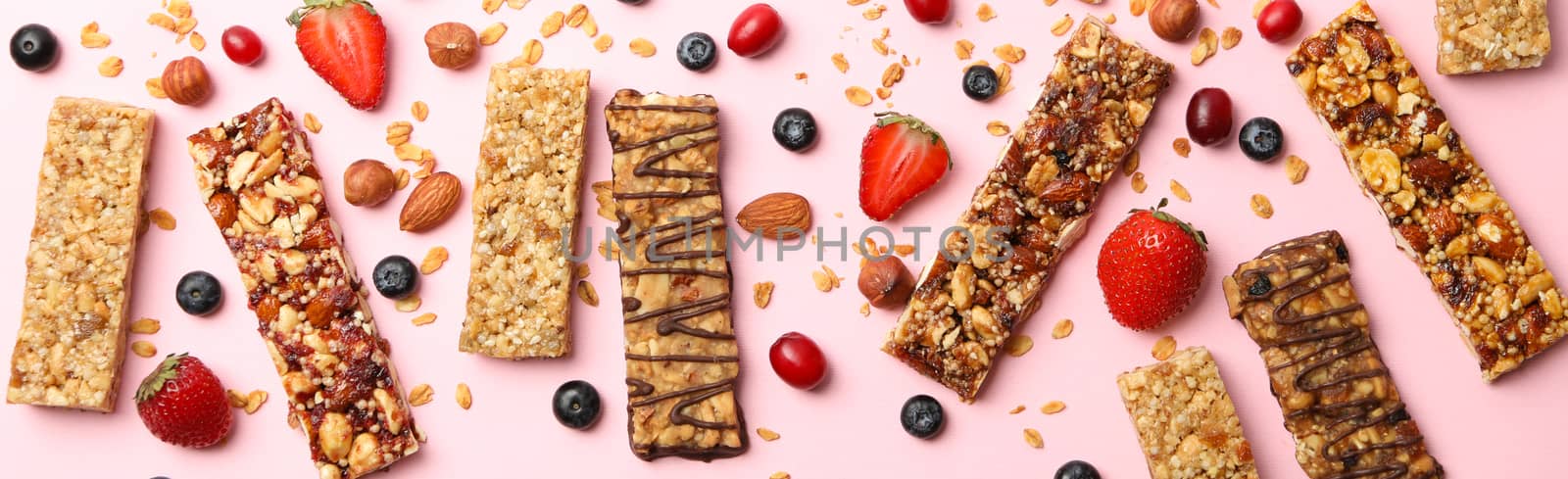 Tasty granola bars on pink background, top view