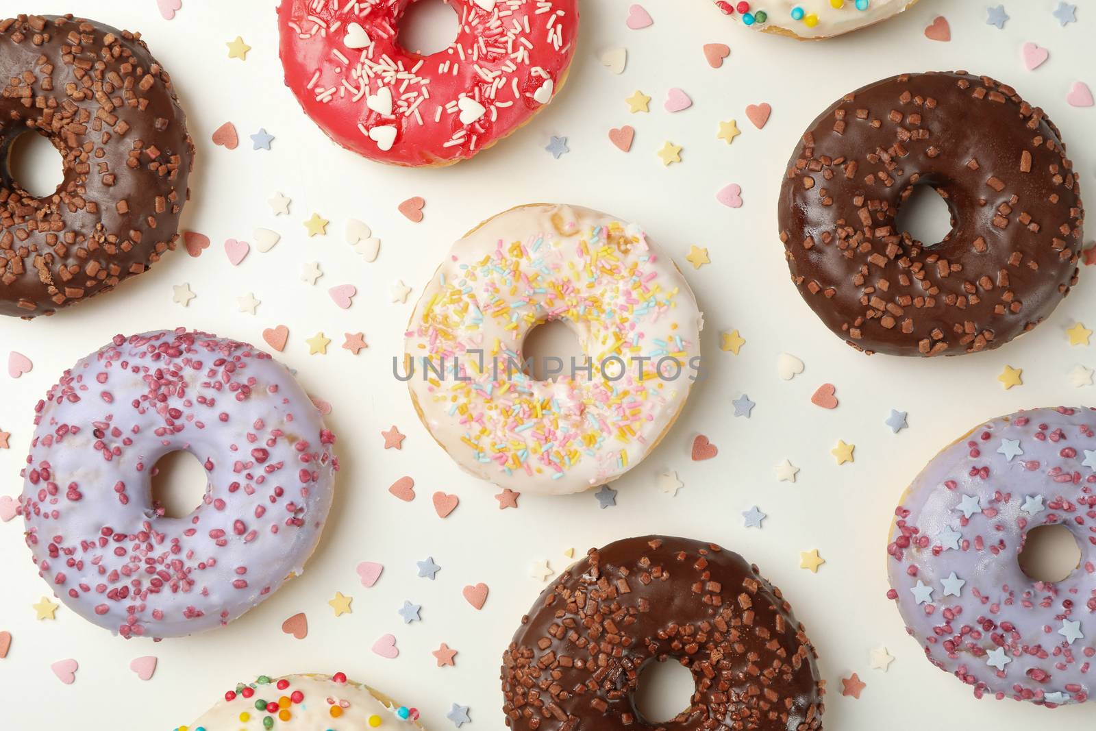 Flat lay with tasty donuts on white background by AtlasCompany