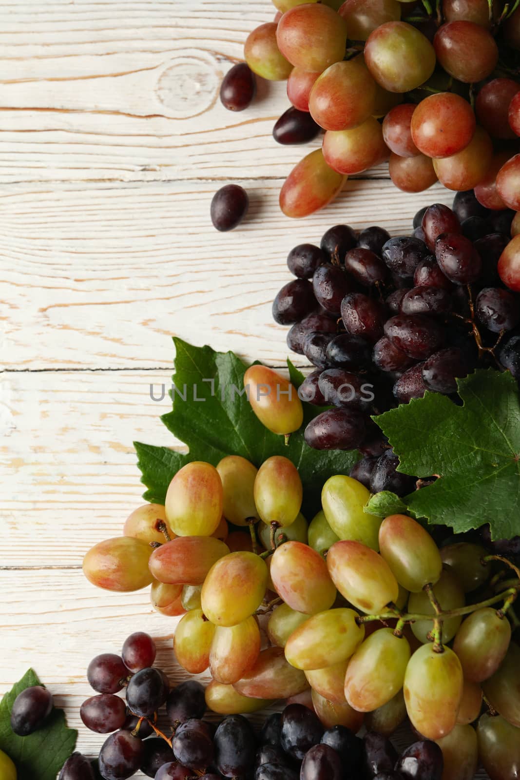 Fresh ripe grape on white wooden background by AtlasCompany