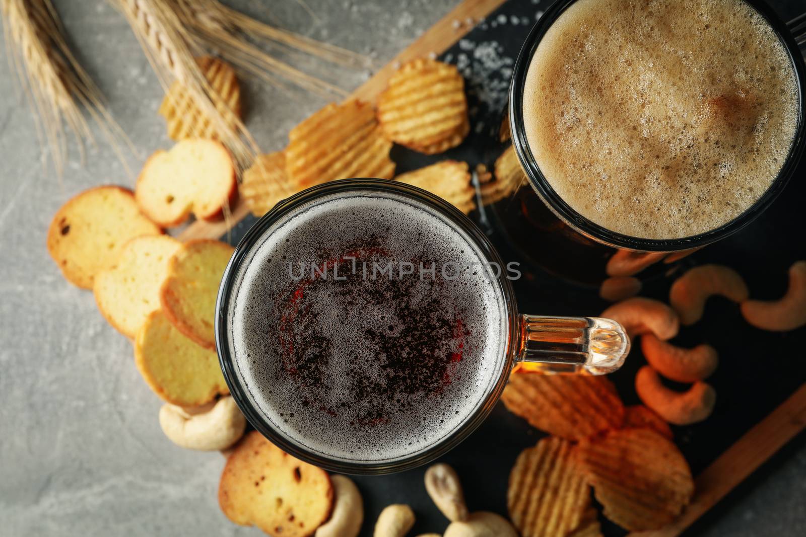 Beer, wheat and snacks on gray table