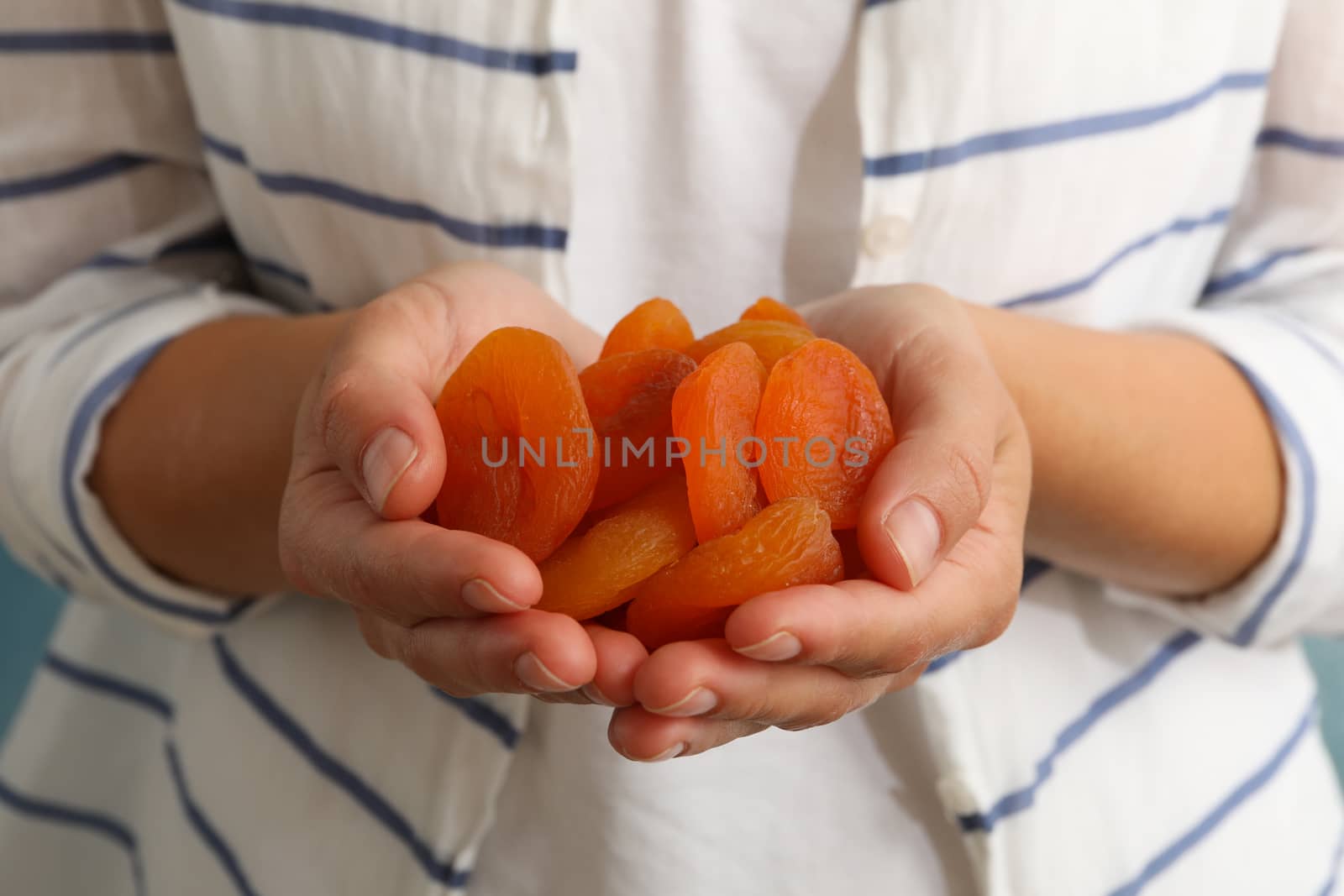 Woman hold tasty dried apricots, close up by AtlasCompany