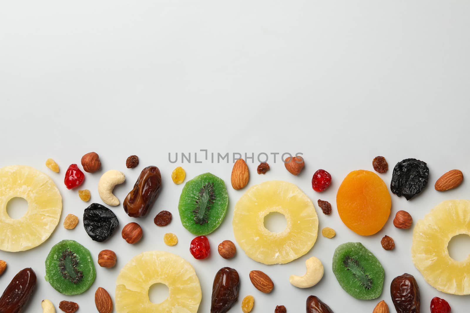 Nuts and dried fruits on gray background, top view by AtlasCompany