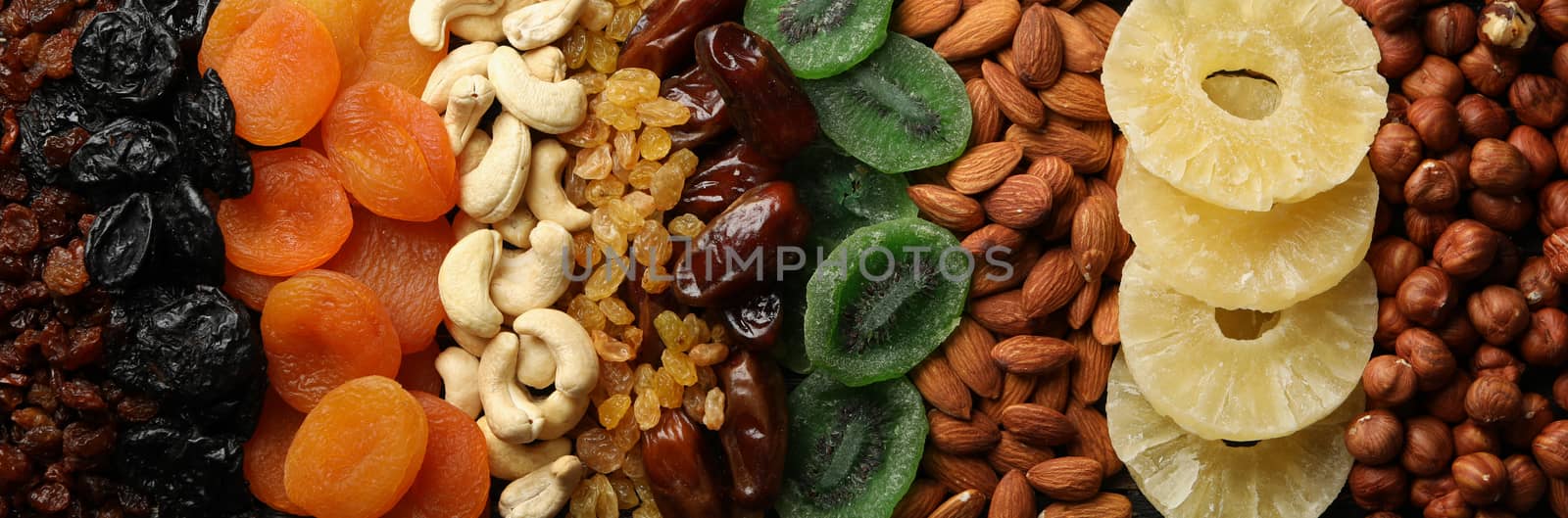 Dried fruits and nuts on wooden background, top view