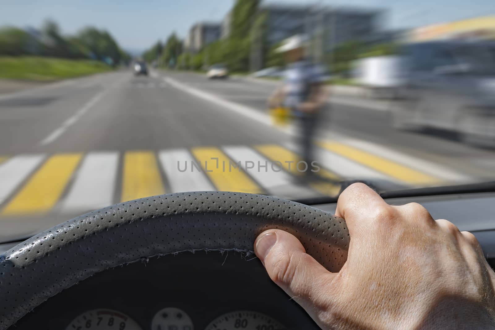 the driver hand on the steering wheel of a car moving at high speed by jk3030