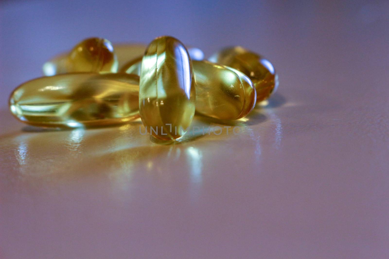 Close up yellow Cod Liver Oil capsule on white background, fish oil is a dietary supplement derived from liver of cod fish, have omega-3 fatty acids, EPA, DHA, vitamin A and .