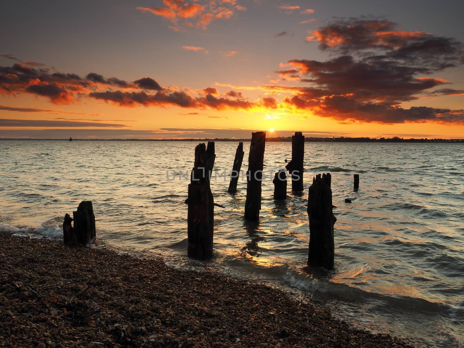 Remains of old wooden jetty looking to Harwich with stunning sunset, Felixstowe by PhilHarland