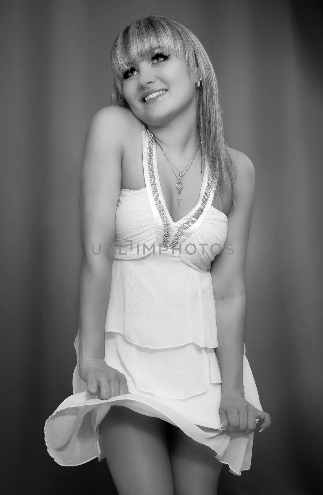 A young shy woman in a white dress is posing by 25ehaag6