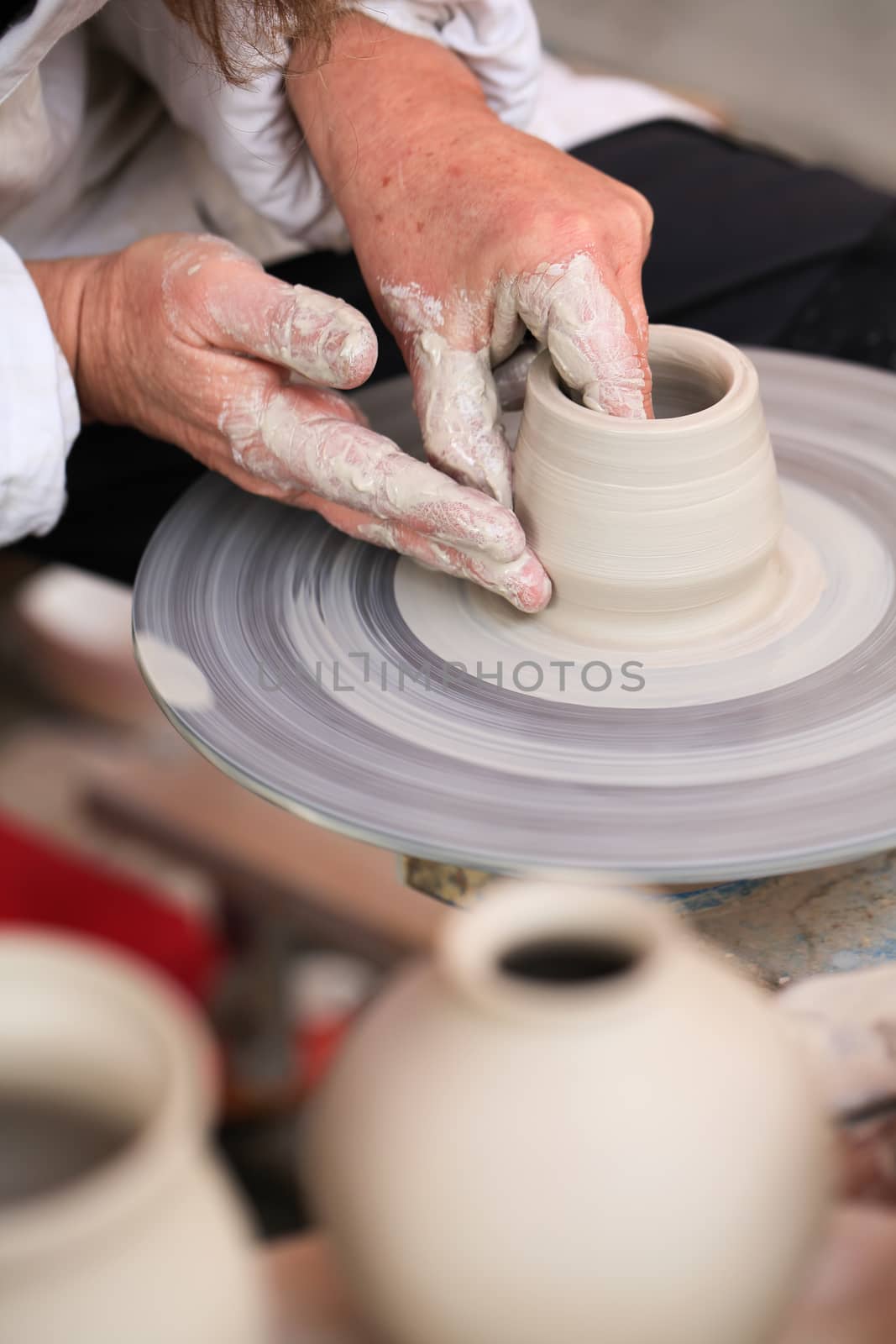 Hands of a potter creating small vases