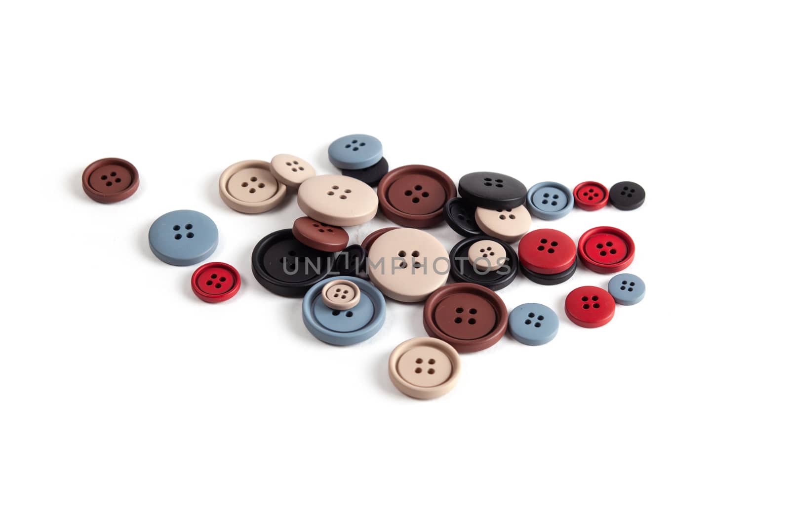 Pile of color brown, beige, grey, red, black plastic matte buttons on white, beautiful needlework, minimalism. Use for sewing. Space for text.