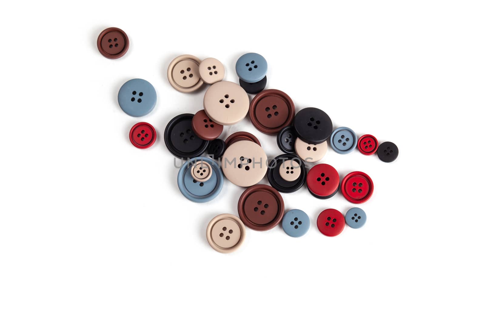 Pile of color brown, beige, grey, red, black plastic matte buttons on white, beautiful needlework, minimalism. Use for sewing. Space for text.