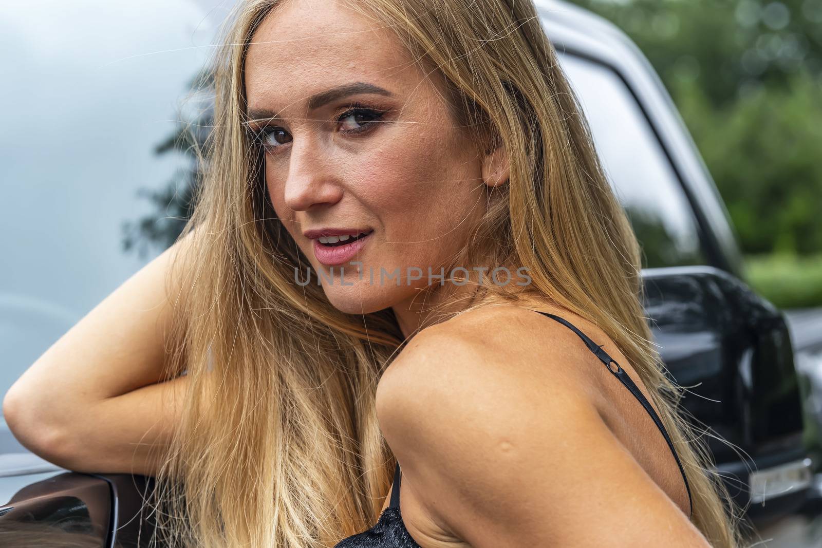 A Lovely Blonde Model Poses Outdoors With Her Black Truck On A Fall Day by actionsports