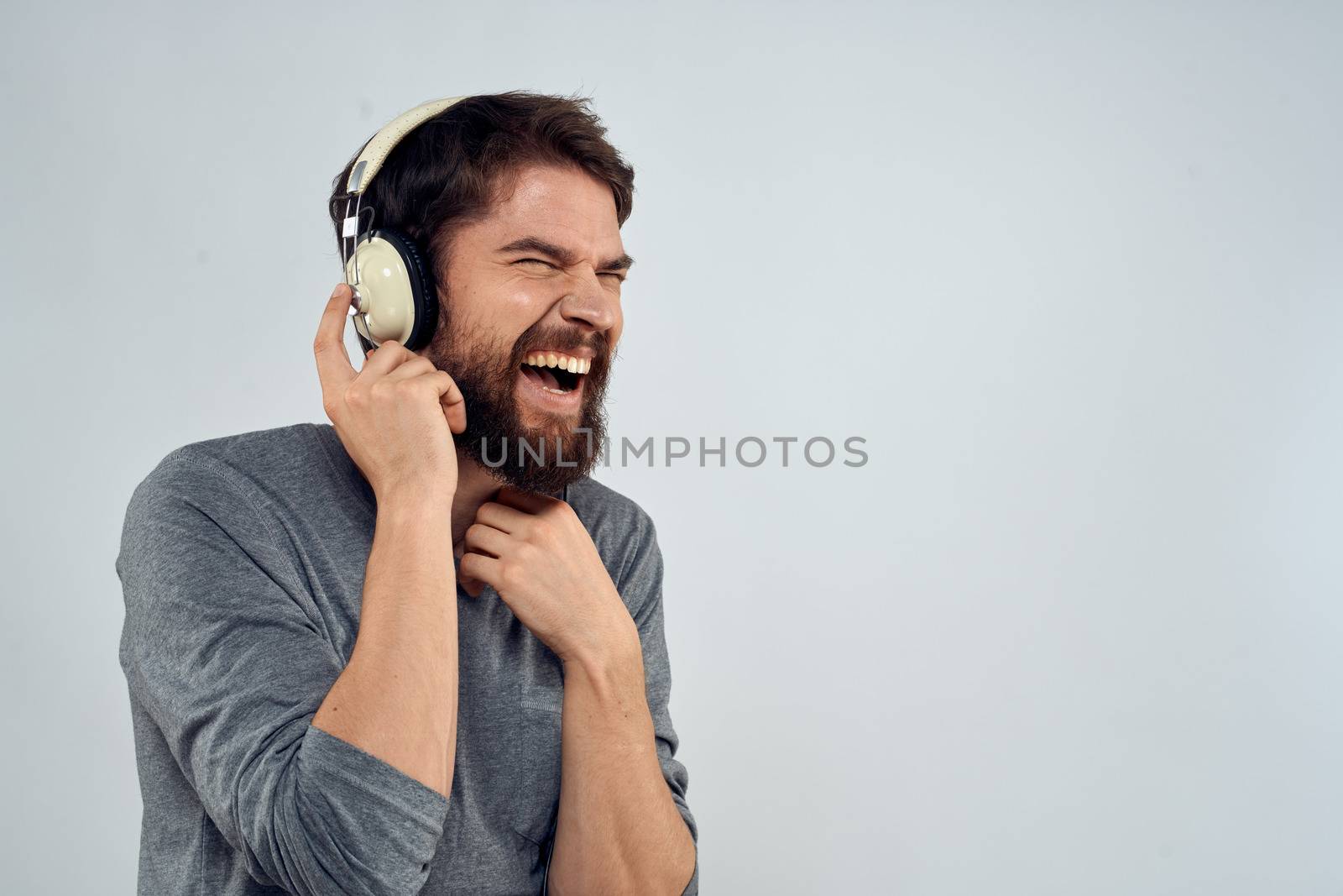 Man in headphones listens to music lifestyle modern style technology light background. High quality photo