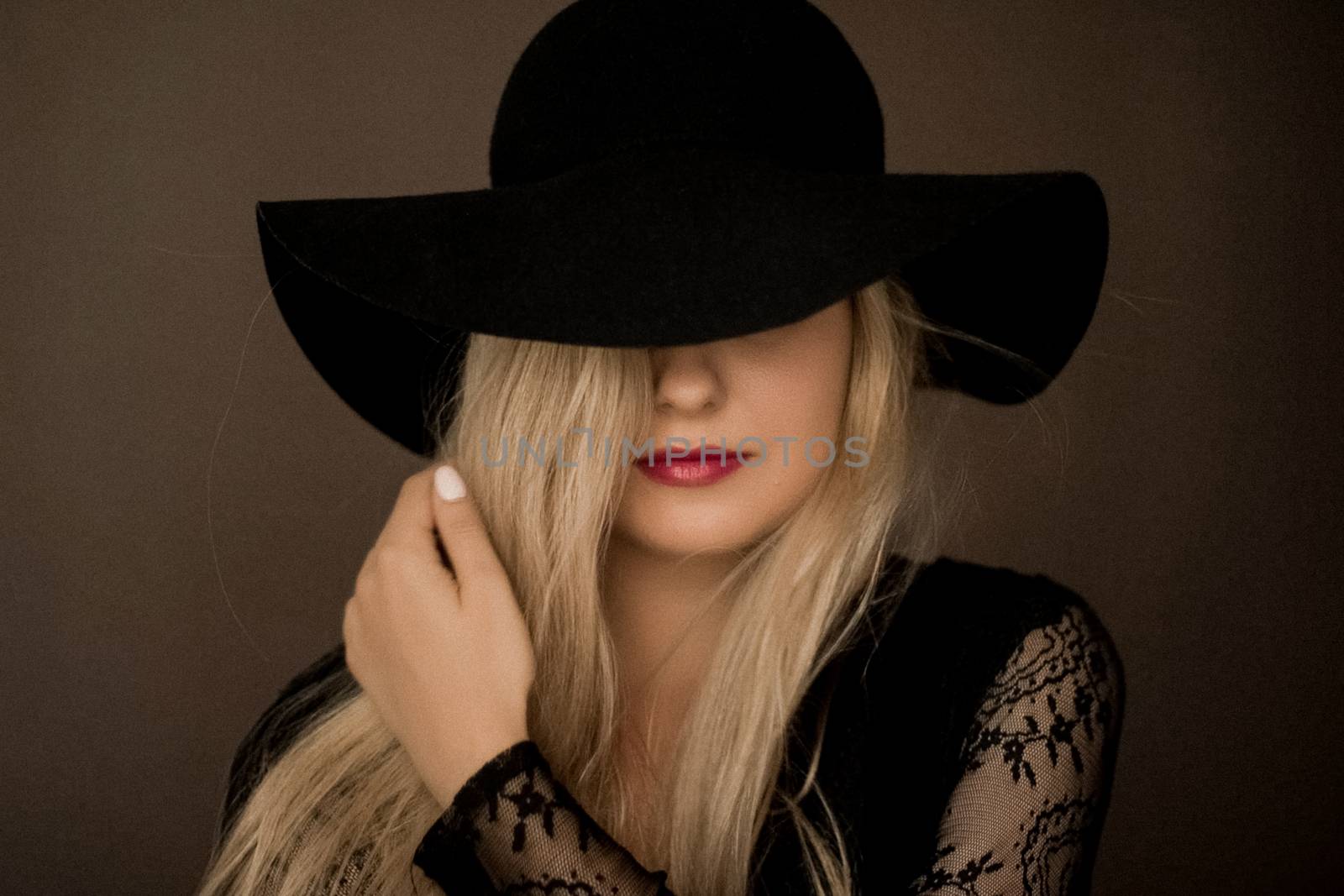 Classy blonde woman wearing a hat, artistic film portrait for fashion campaign and beauty brand design