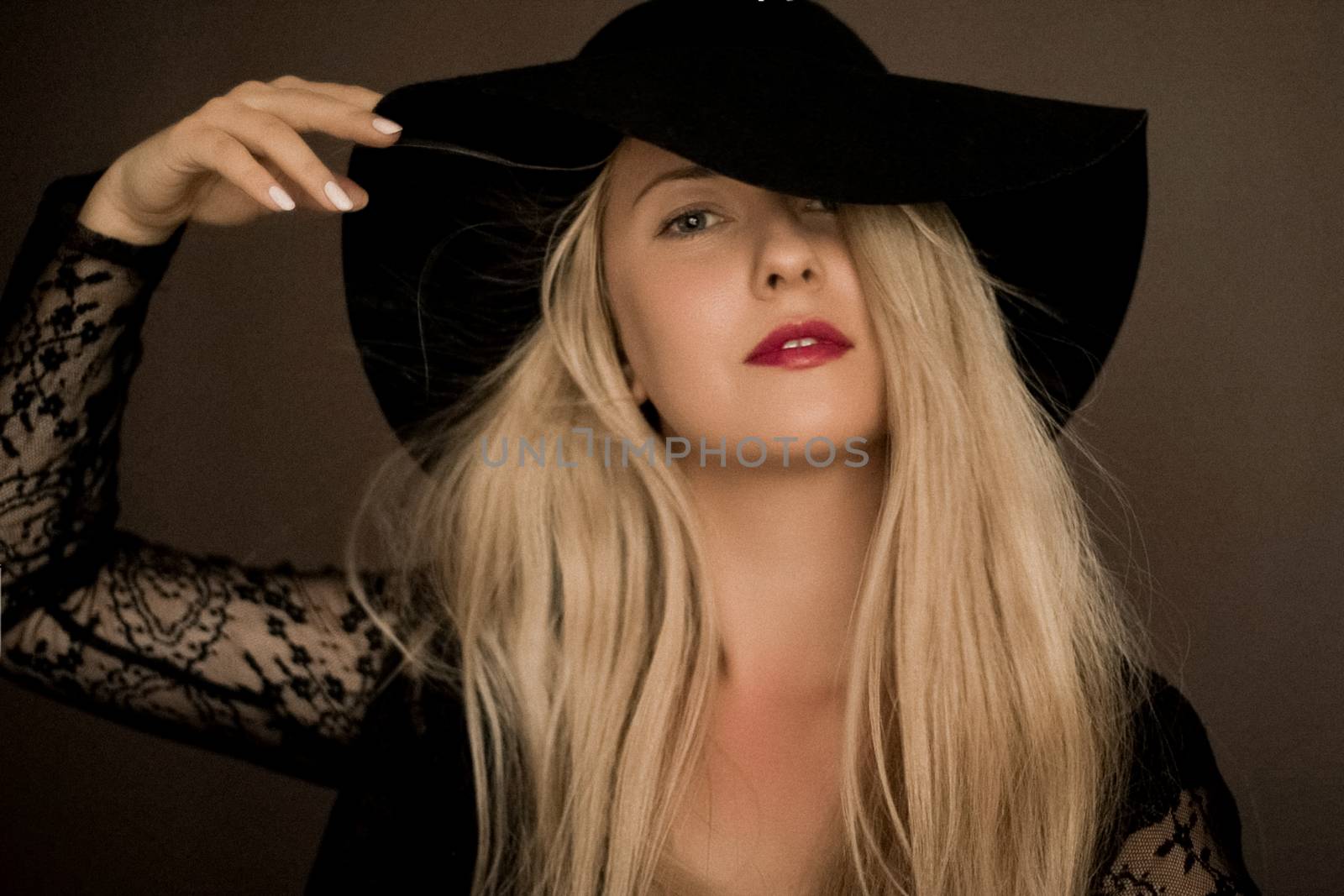 Classy blonde woman wearing a hat, artistic film portrait for fashion campaign and beauty brand design