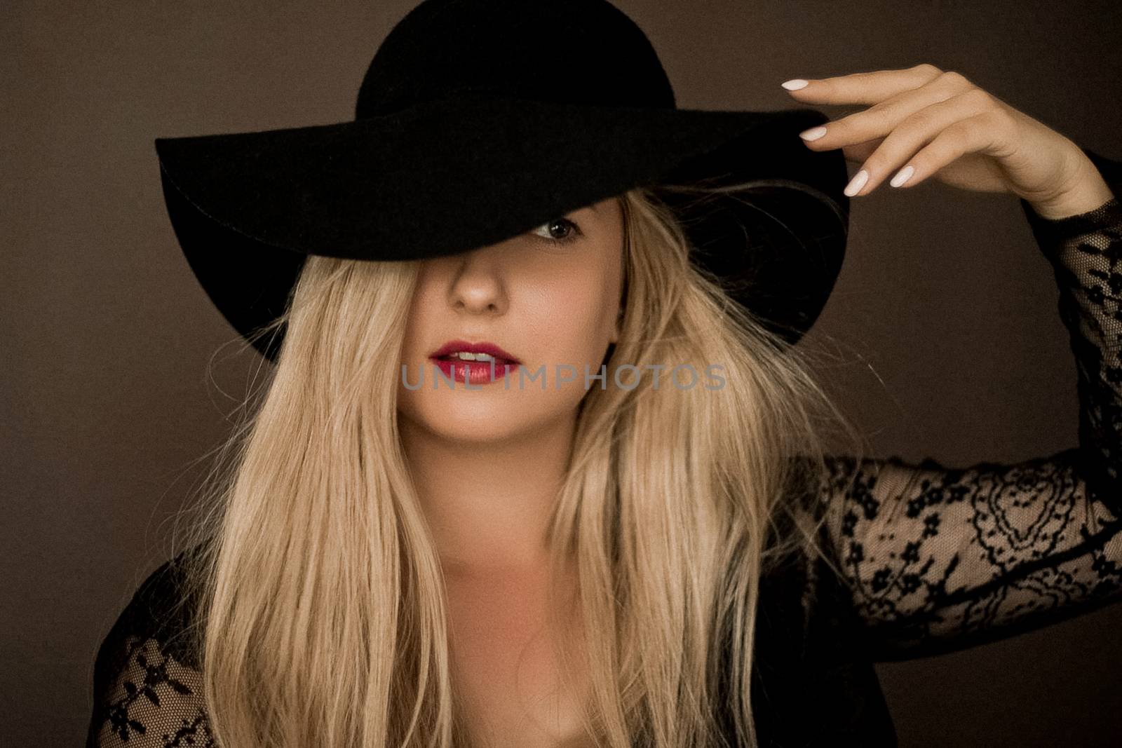 Classy blonde woman wearing a hat, artistic film portrait for fashion campaign and beauty brand design