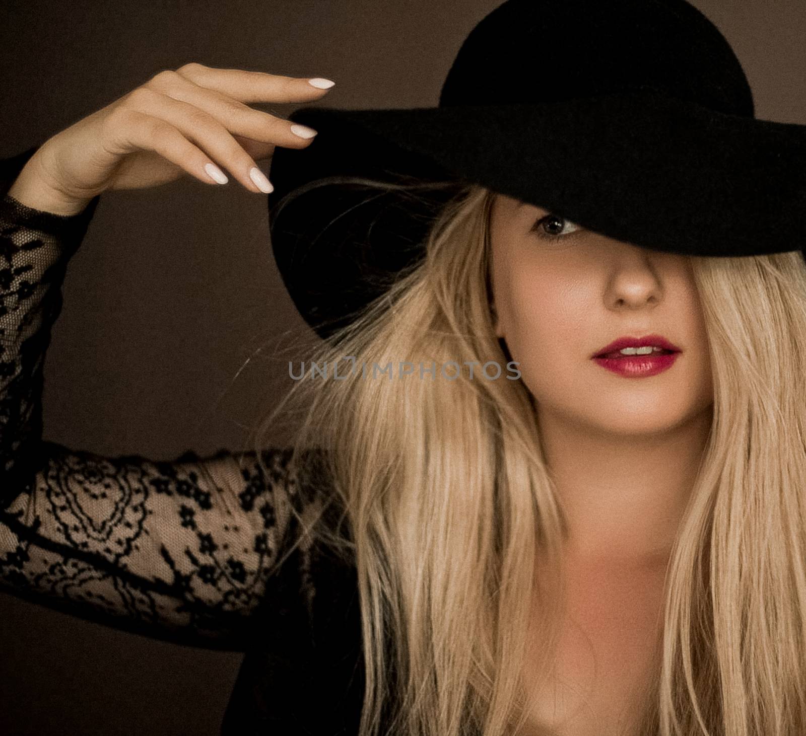 Classy blonde woman wearing a hat, artistic film portrait for fashion campaign and beauty brand design