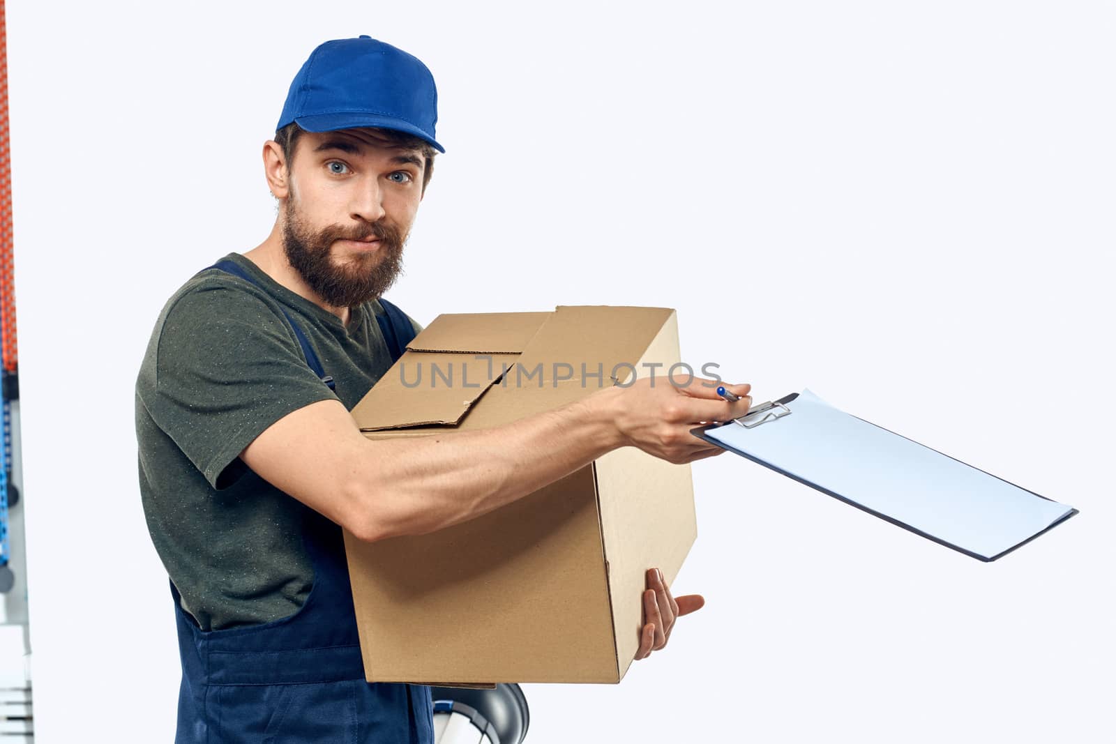 Working male courier with box in hand documents delivery service light background. High quality photo