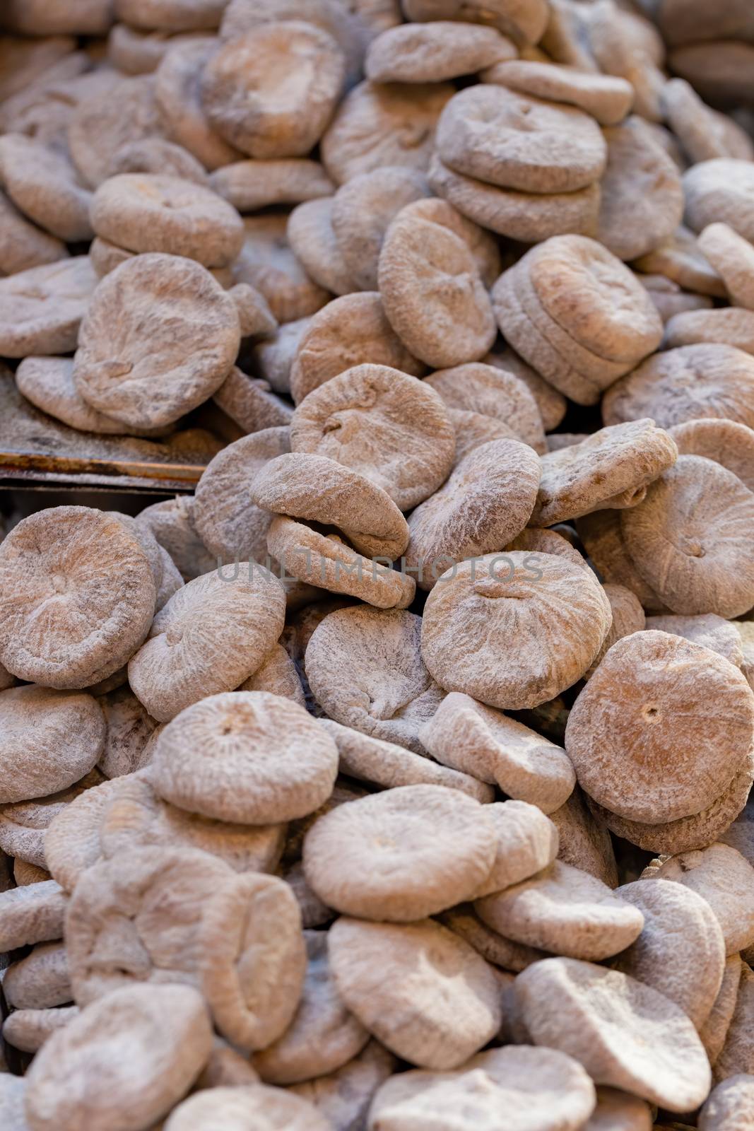 Pile of dried figs, coated in wheat flour, on a market stall