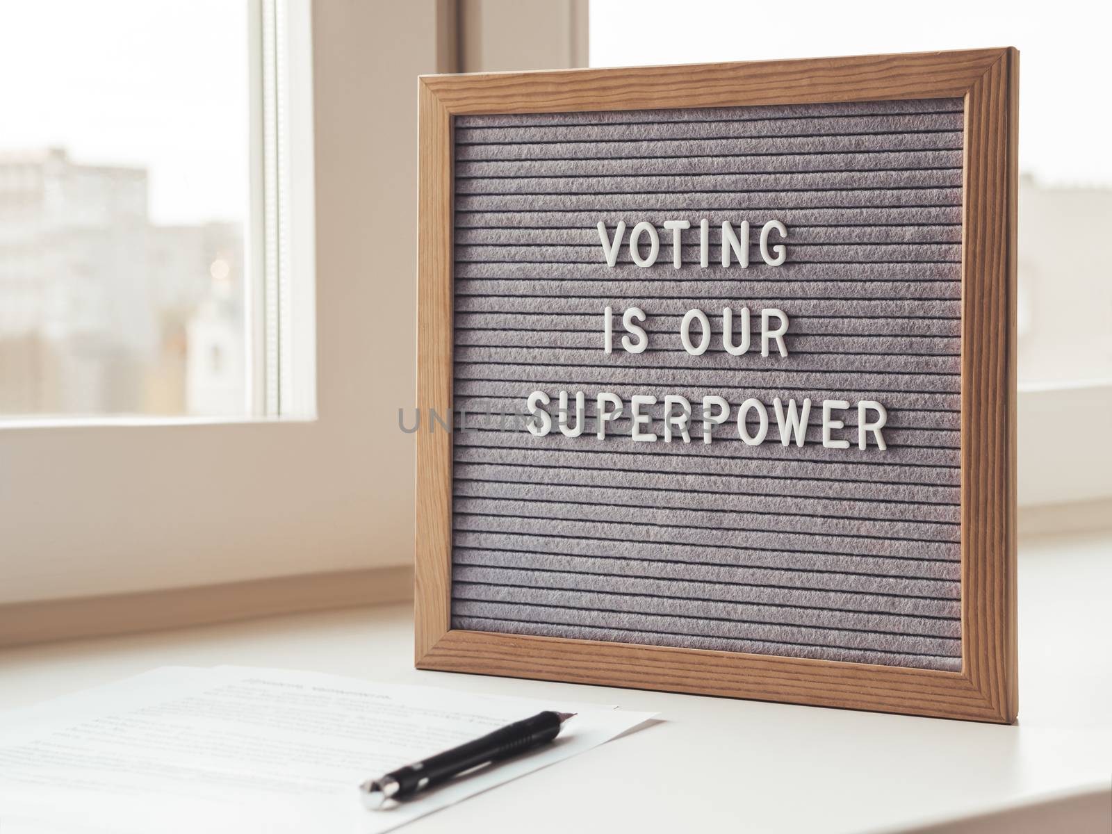 Letter board with phrase Voting is our superpower. Announcement of USA Presidential Election at 3rd November 2020. Call to go to the vote. Paper ballot and pen on window sill.