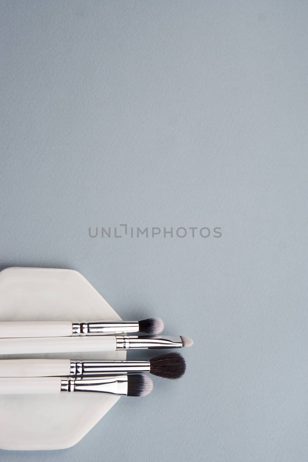 makeup brushes on gray background and stand cropped view Copy Space by SHOTPRIME