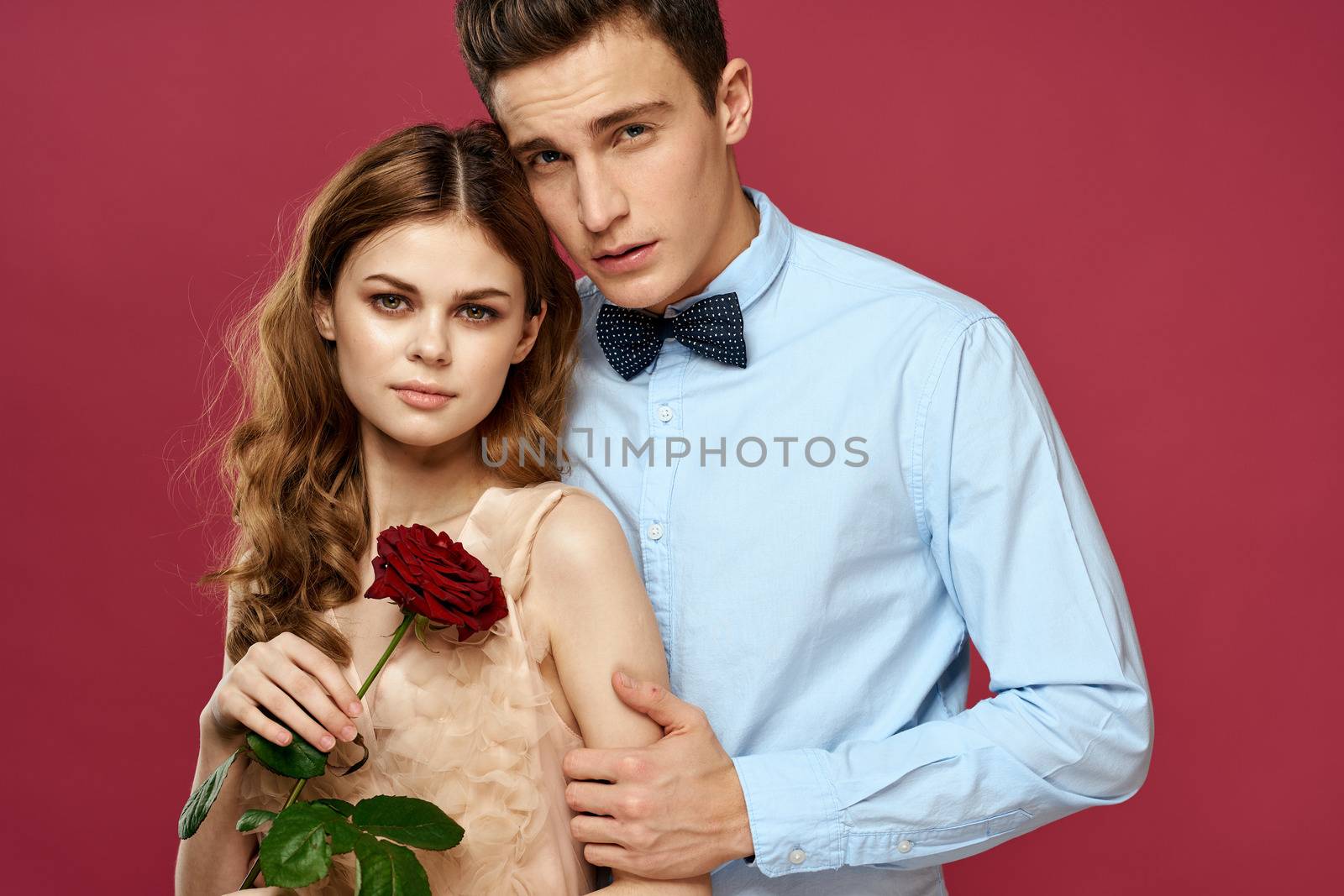 portrait of romantic couple in love with red rose on isolated background and classic suit evening dress. High quality photo
