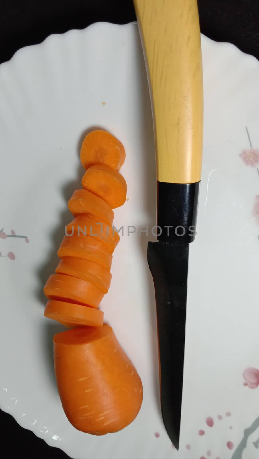 Fresh and delicious and healthy carrot pieces and a knife on plate