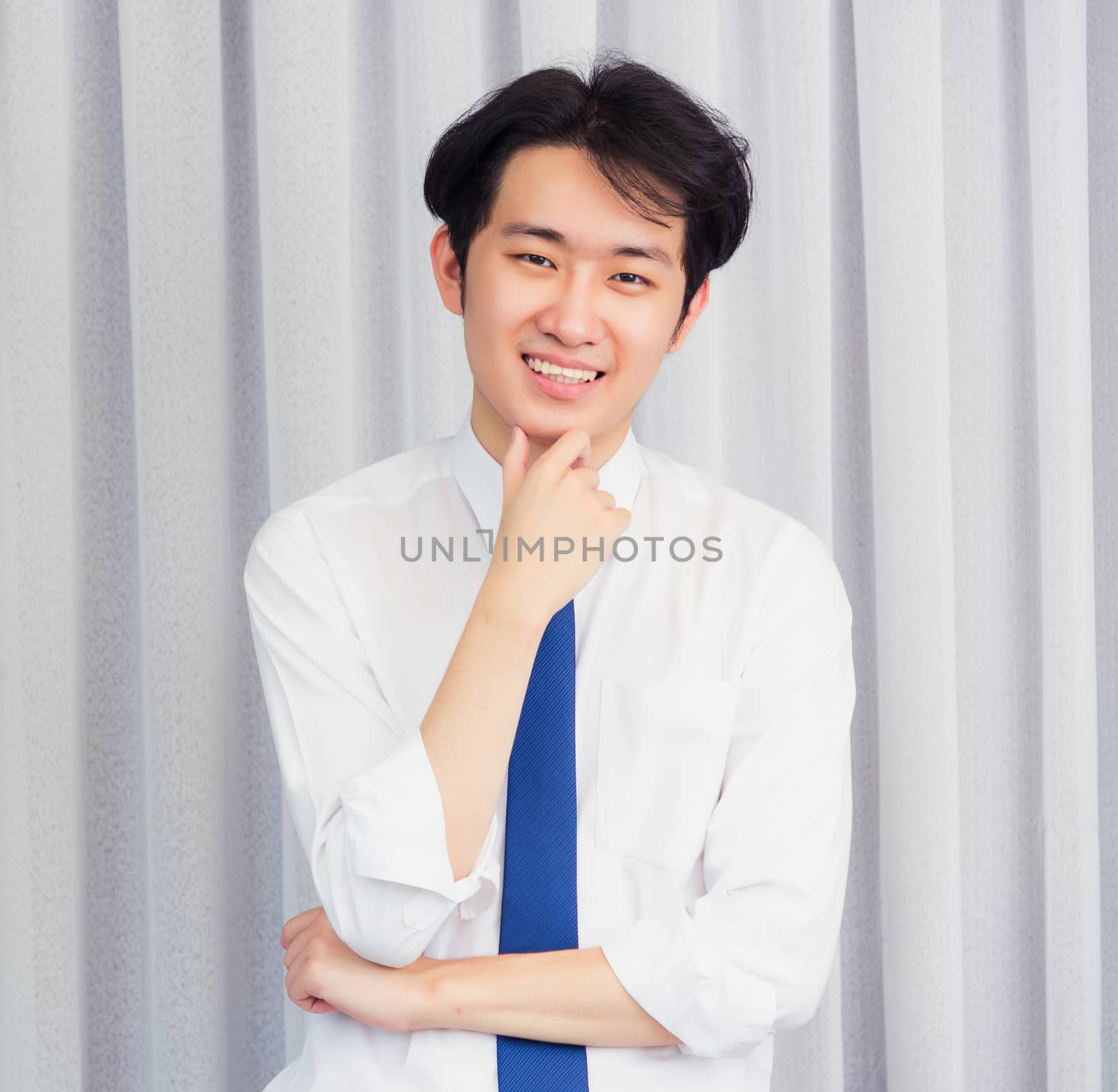 Portrait of happy business handsome man confident wearing shirt pose standing smiling looking to camera he take the hand to hold the chin