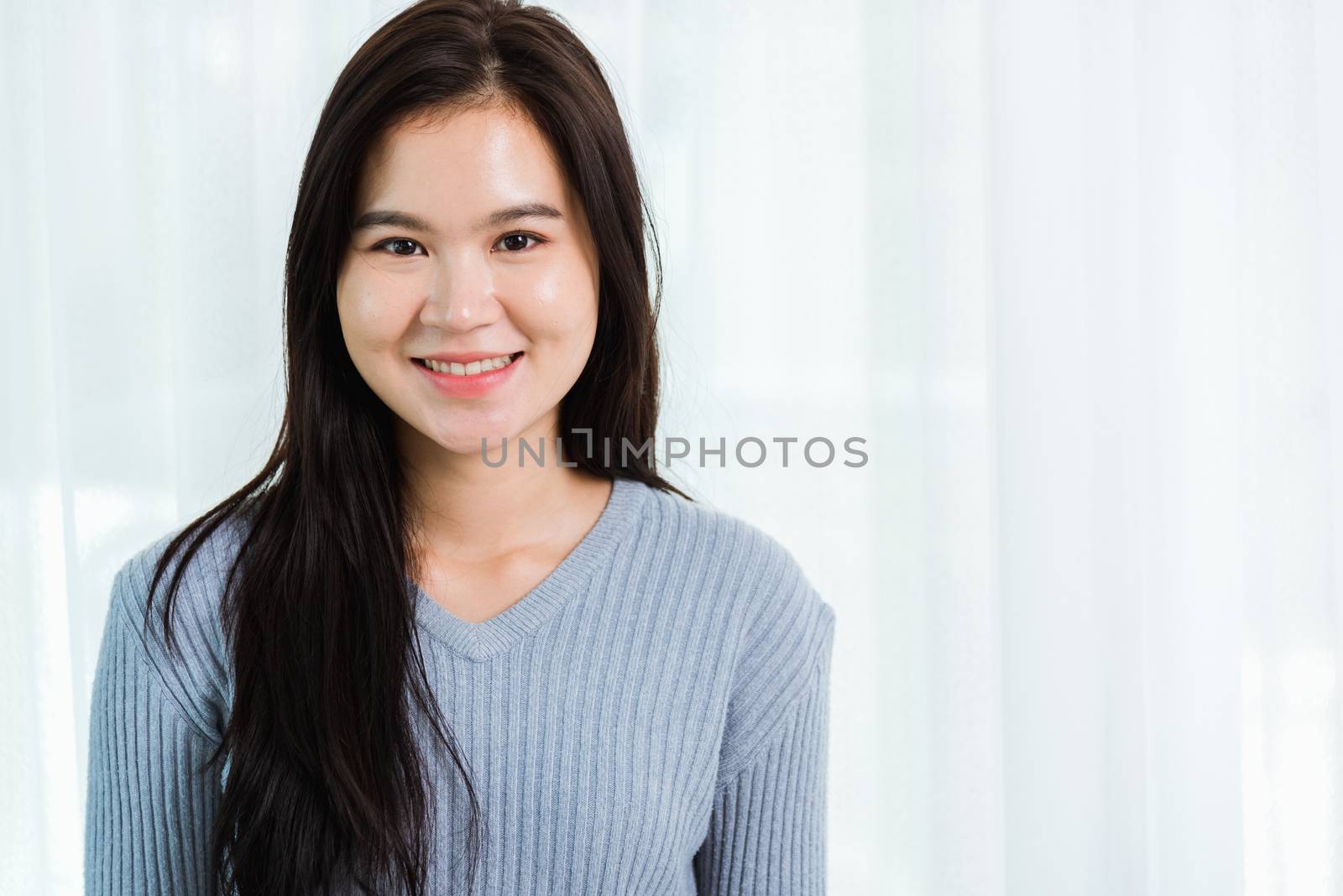 Close up headshot portrait young Asian happy beautiful woman healthy smiling face long hair, studio shot looking to camera at home and have a copy space for your text