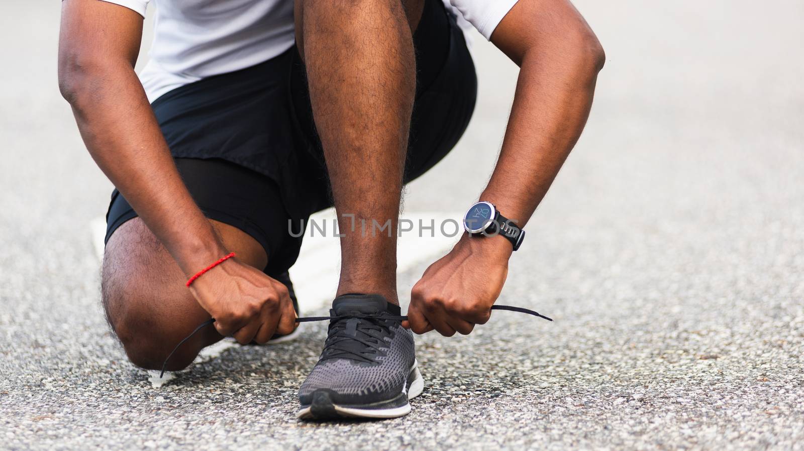 Close up Asian sport runner black man wear watch sitting he trying shoelace running shoes getting ready for jogging and run outdoor street health park with copy space, healthy exercise workout concept