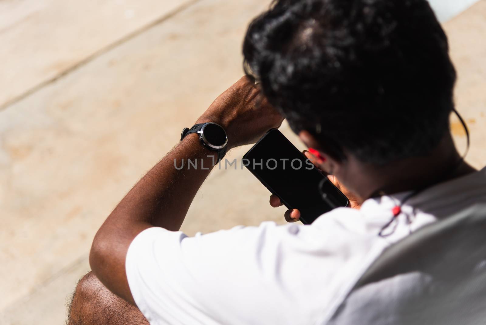 Close up Asian young athlete sport runner black man wear modern time smart watch and sync to a smartphone check running result after a training run at the outdoor, healthy exercise workout technology