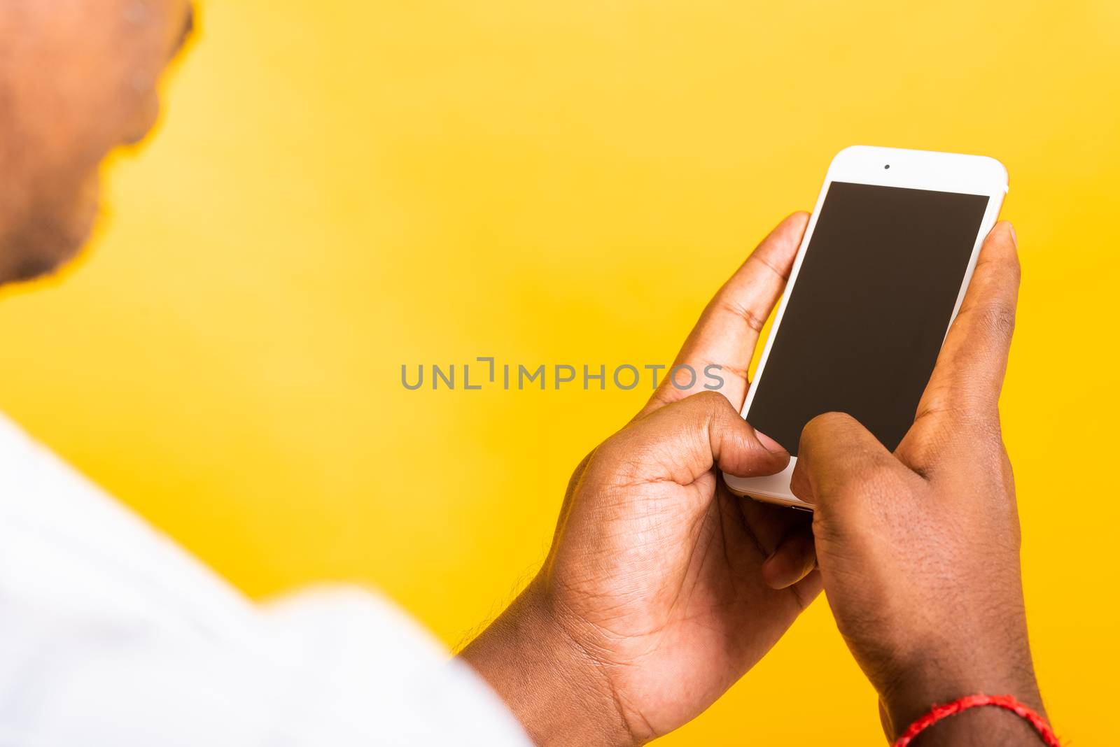 Closeup Asian happy portrait young black man holding digital mobile smartphone blank screen space on hands, studio isolated on yellow background