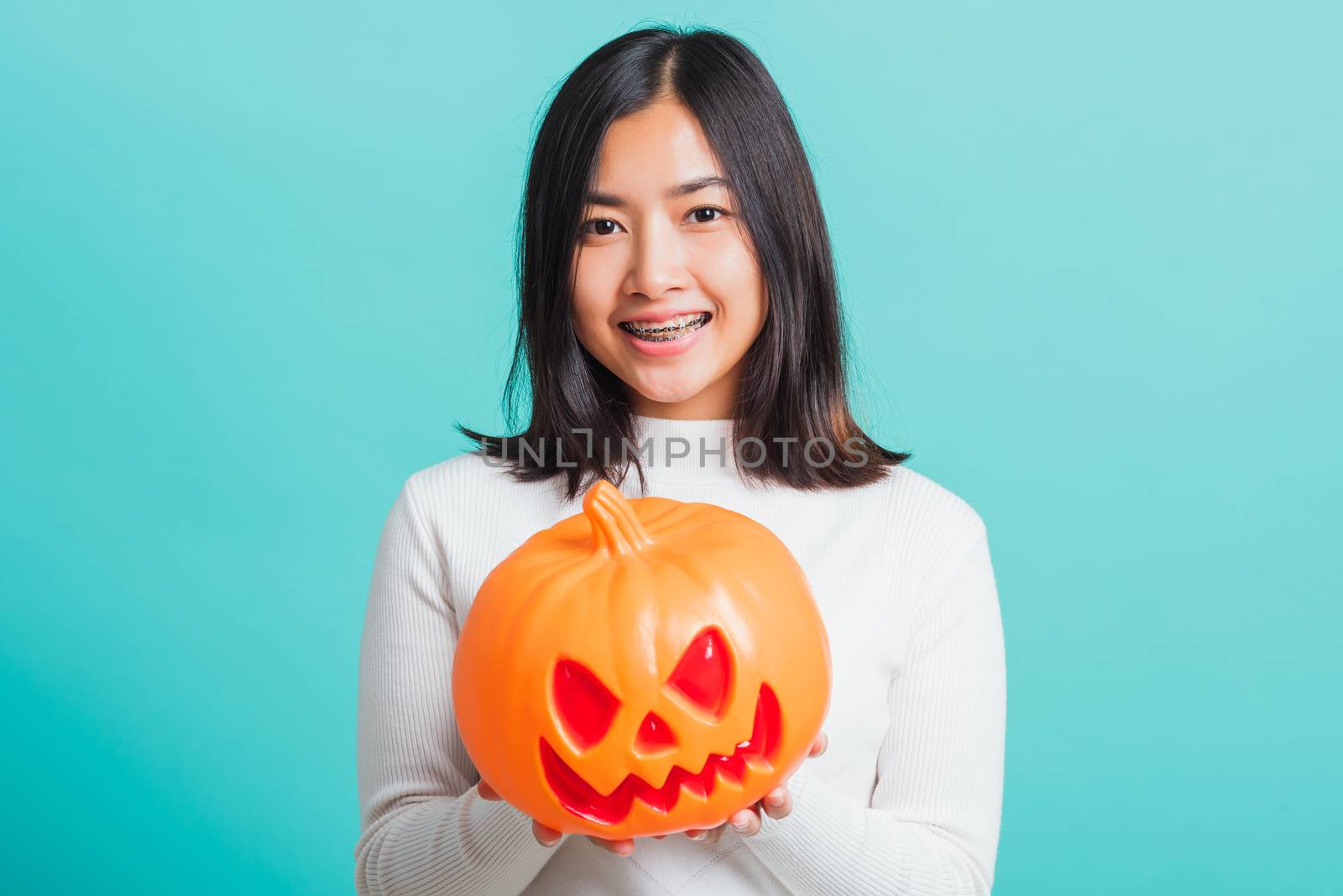 woman holding orange model pumpkins by Sorapop