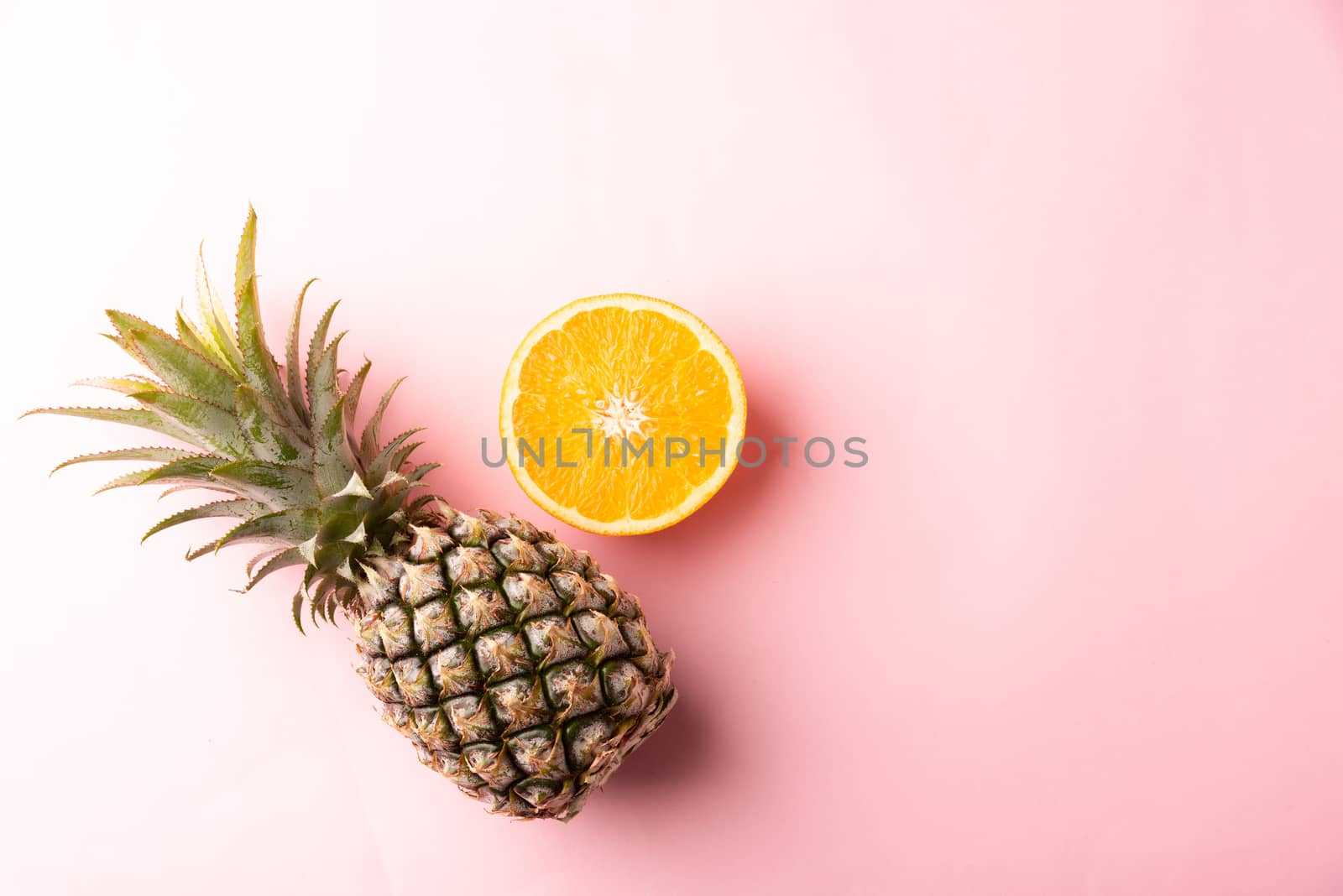 Close up above top view of ripe pineapple and orange fruit on pink pastel background, Summer Tropical, Healthy lifestyle diet food concept
