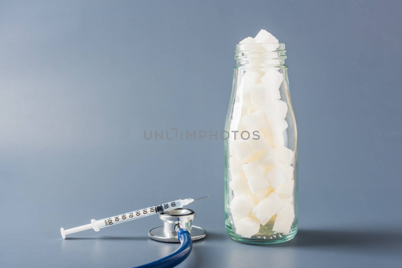 Glass bottle full of white sugar cube by Sorapop
